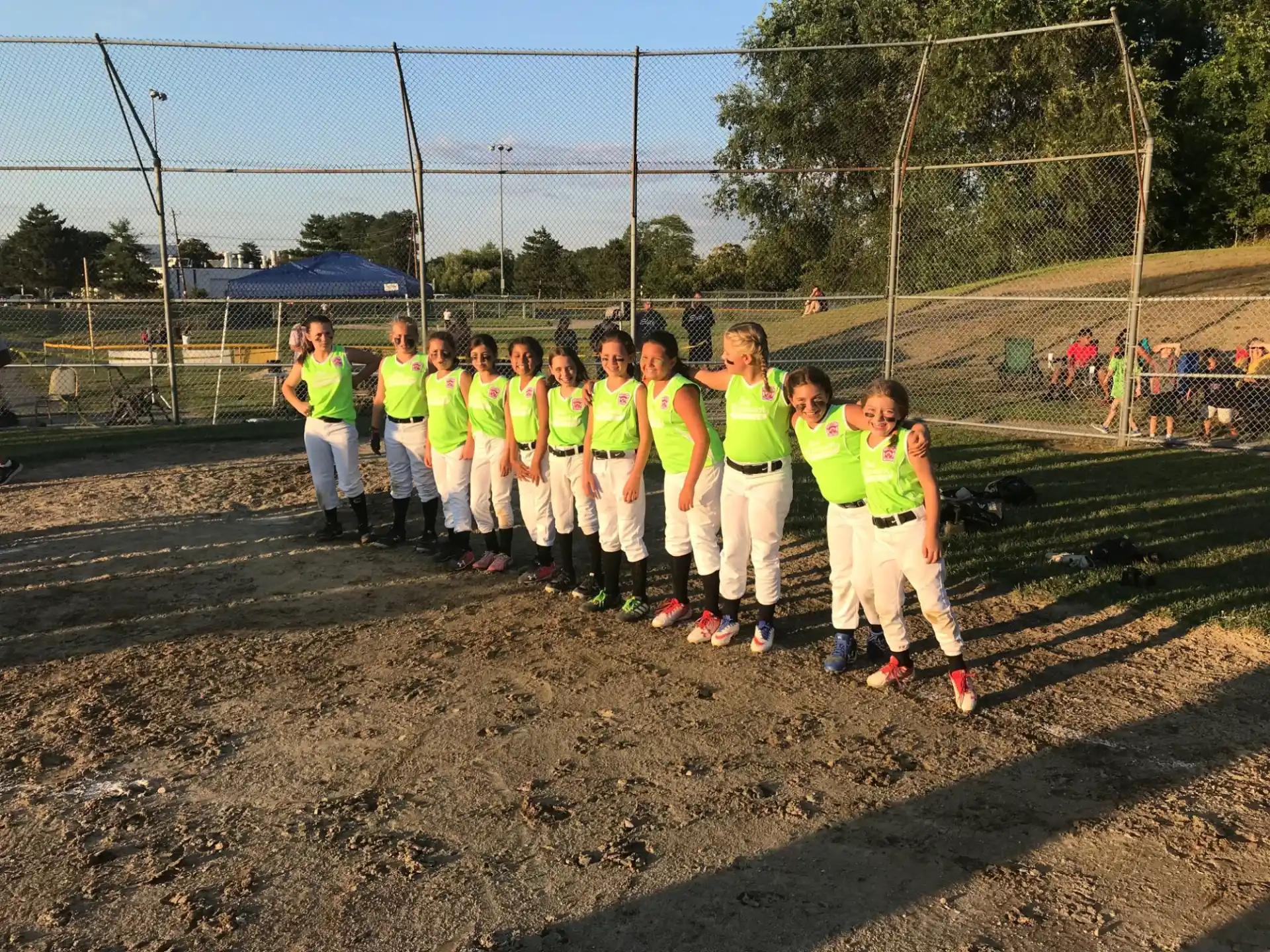 a group of people in matching t-shirts standing on a dirt field