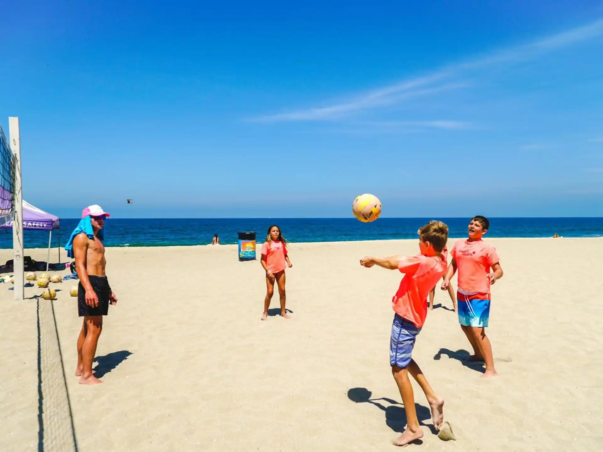 a group of people play volleyball on a beach