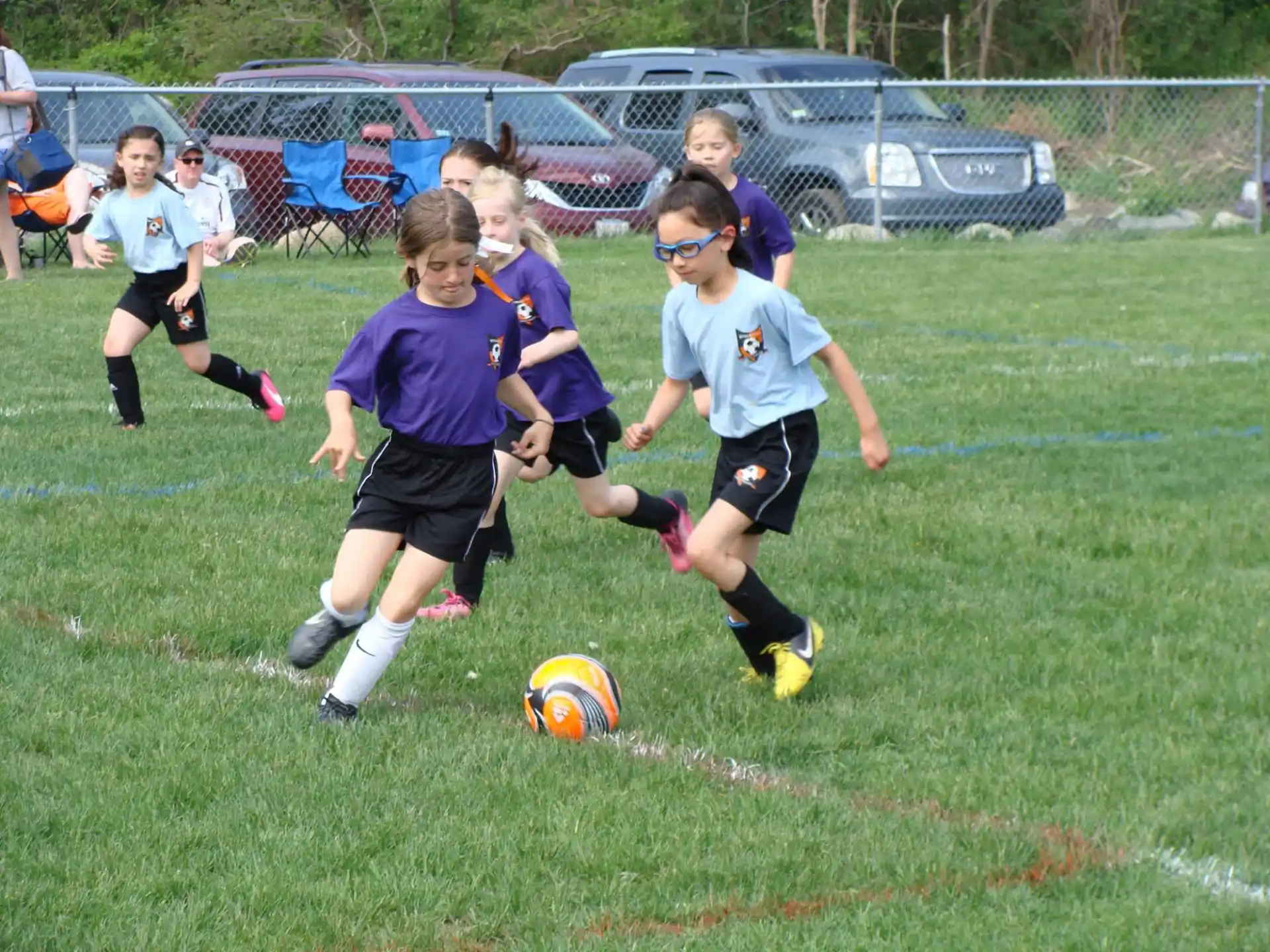 a group of kids compete over a football ball