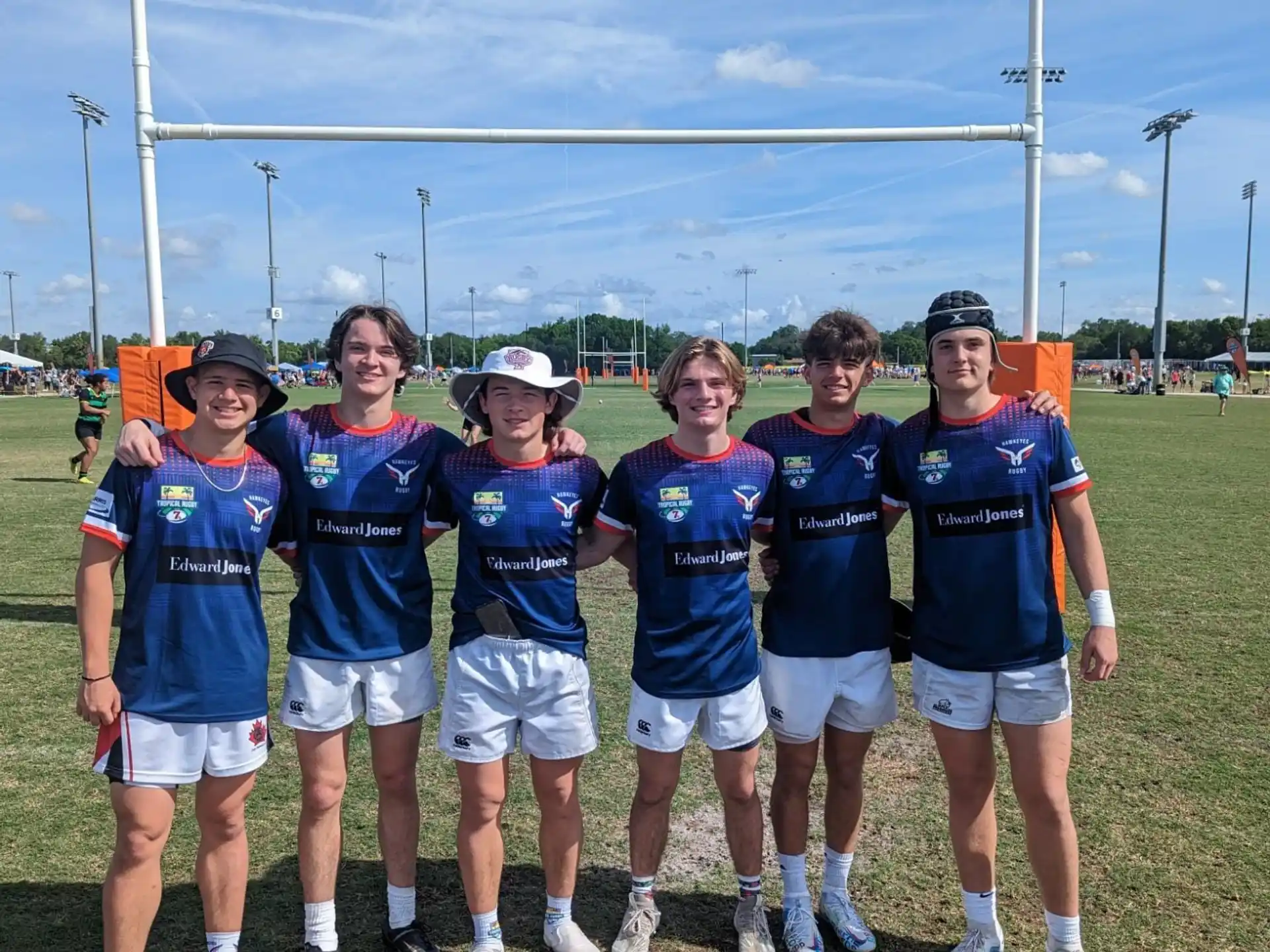 a group of people wearing matching blue shirts and standing on a field