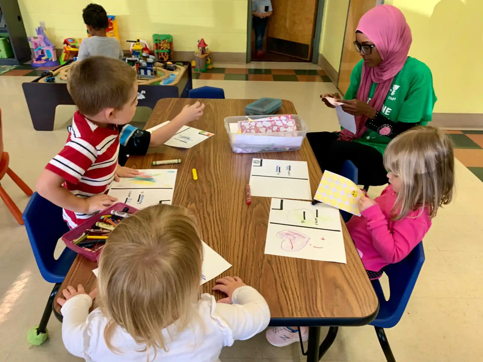 a group of children sitting at a table with paper on it