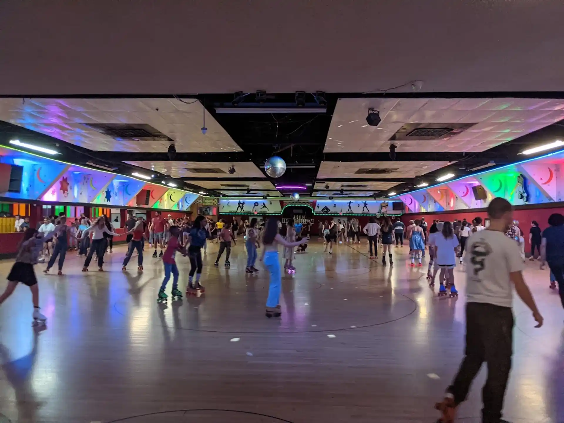 a group of people in a large room with a stage and lights