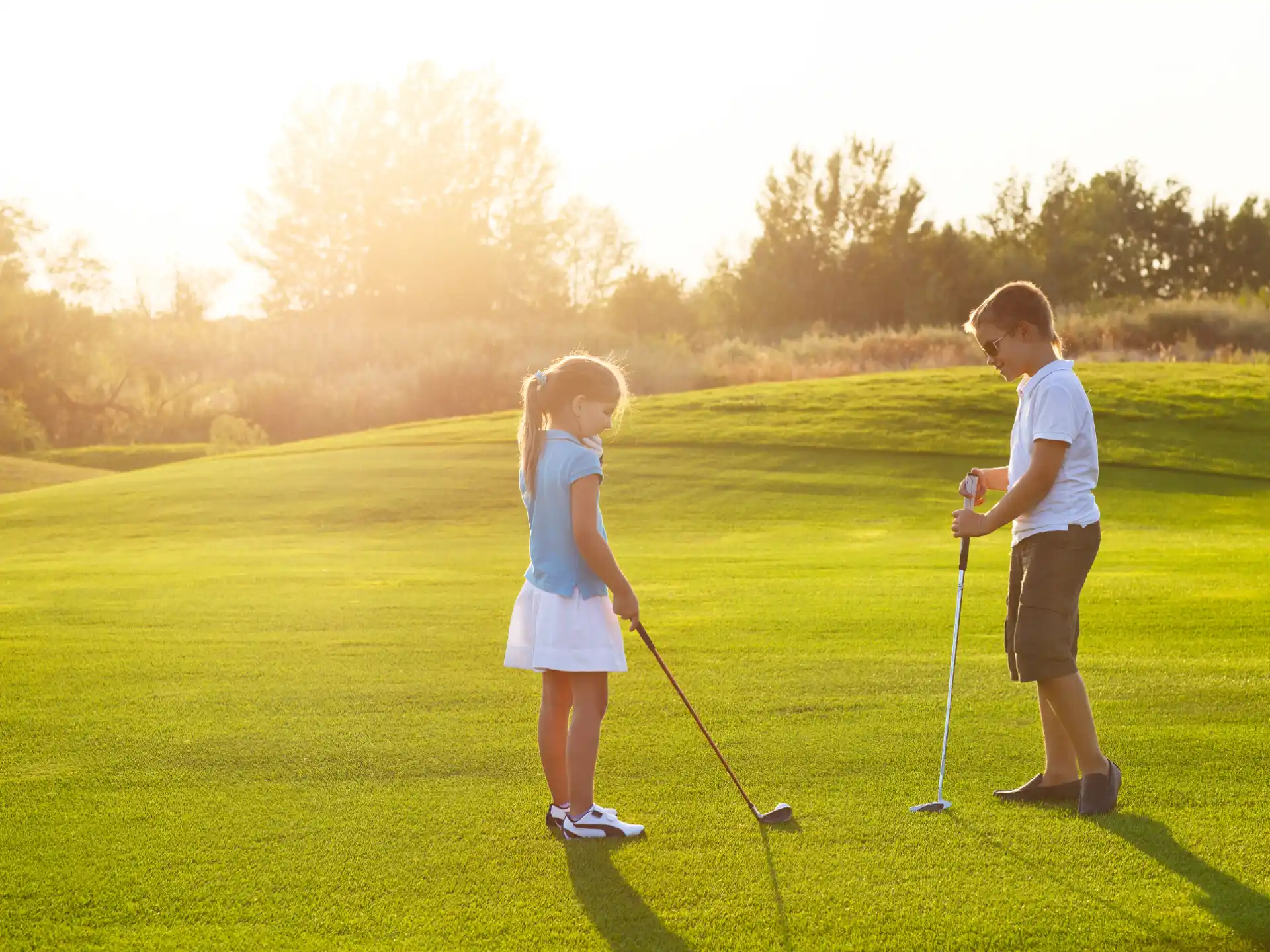 a boy and girl playing golf