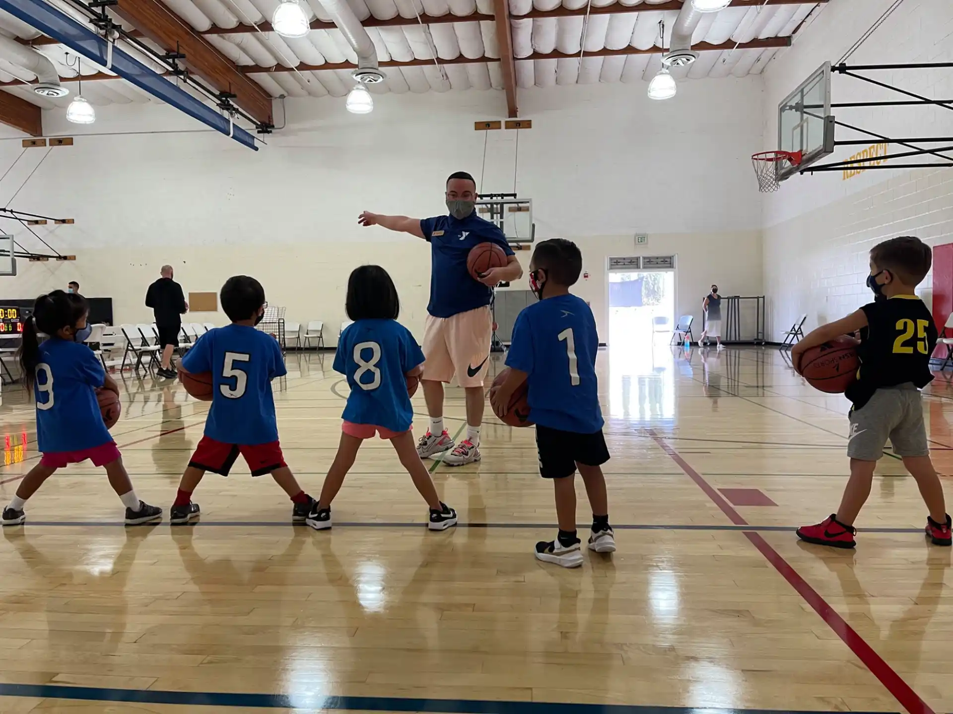 a person and a group of kids playing basketball