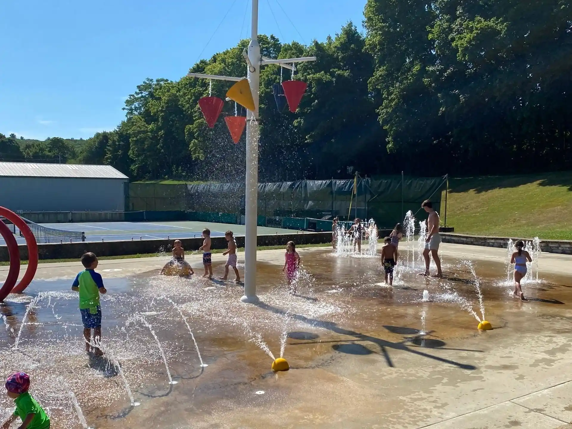 a group of people playing in a water fountain