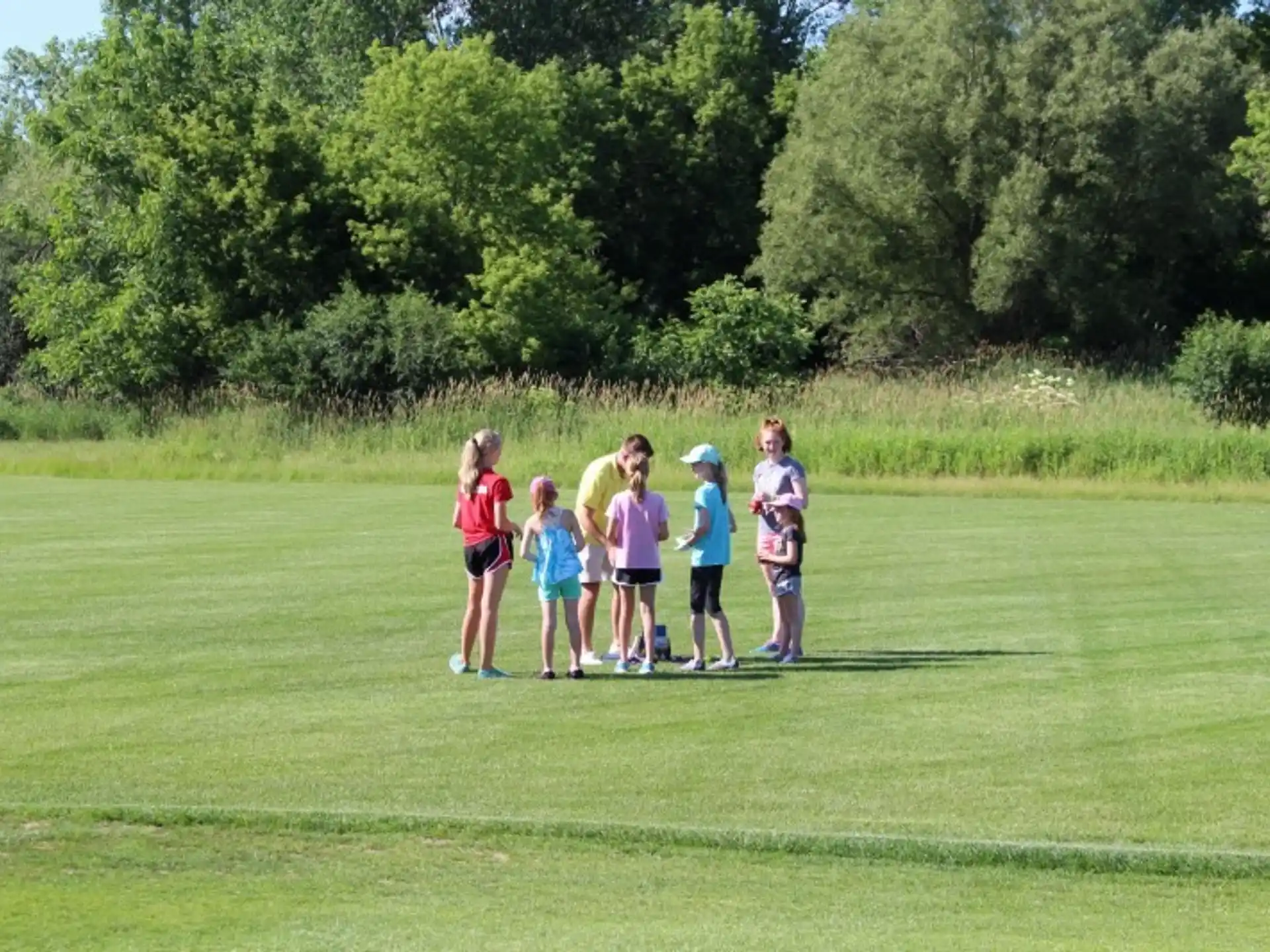 a group of people standing on a grass field