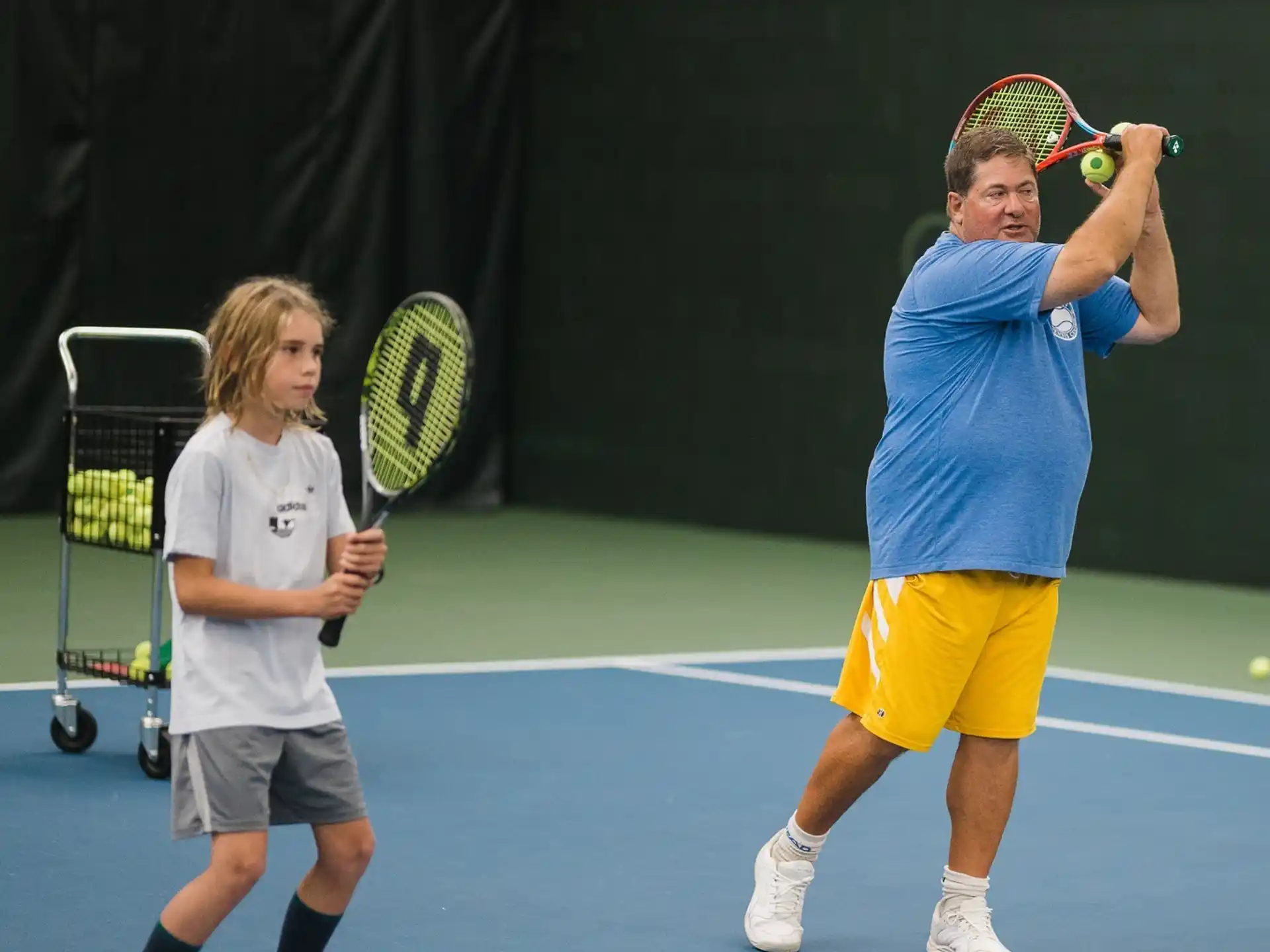 a couple of people play tennis