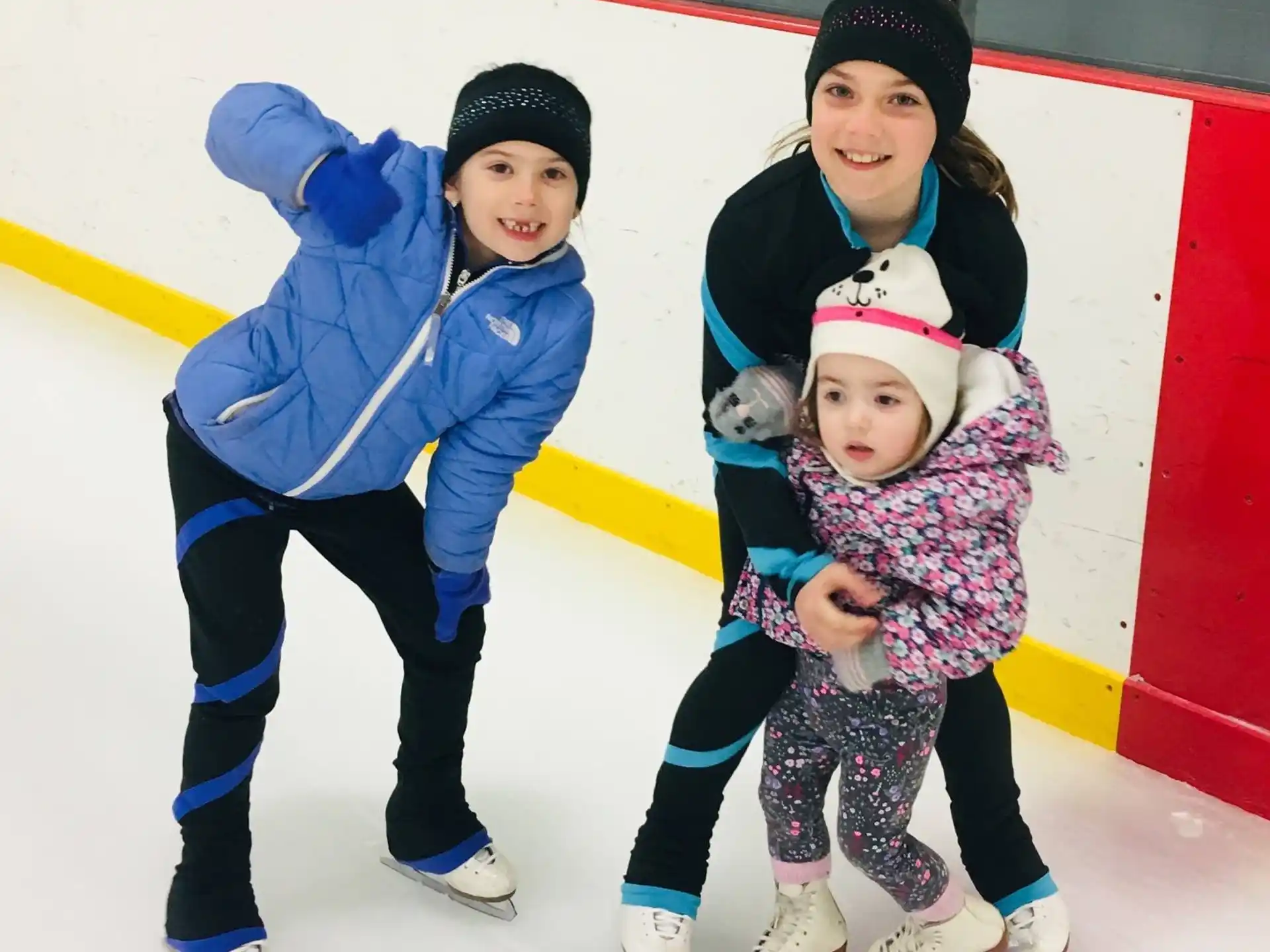 a person and two children on an ice rink