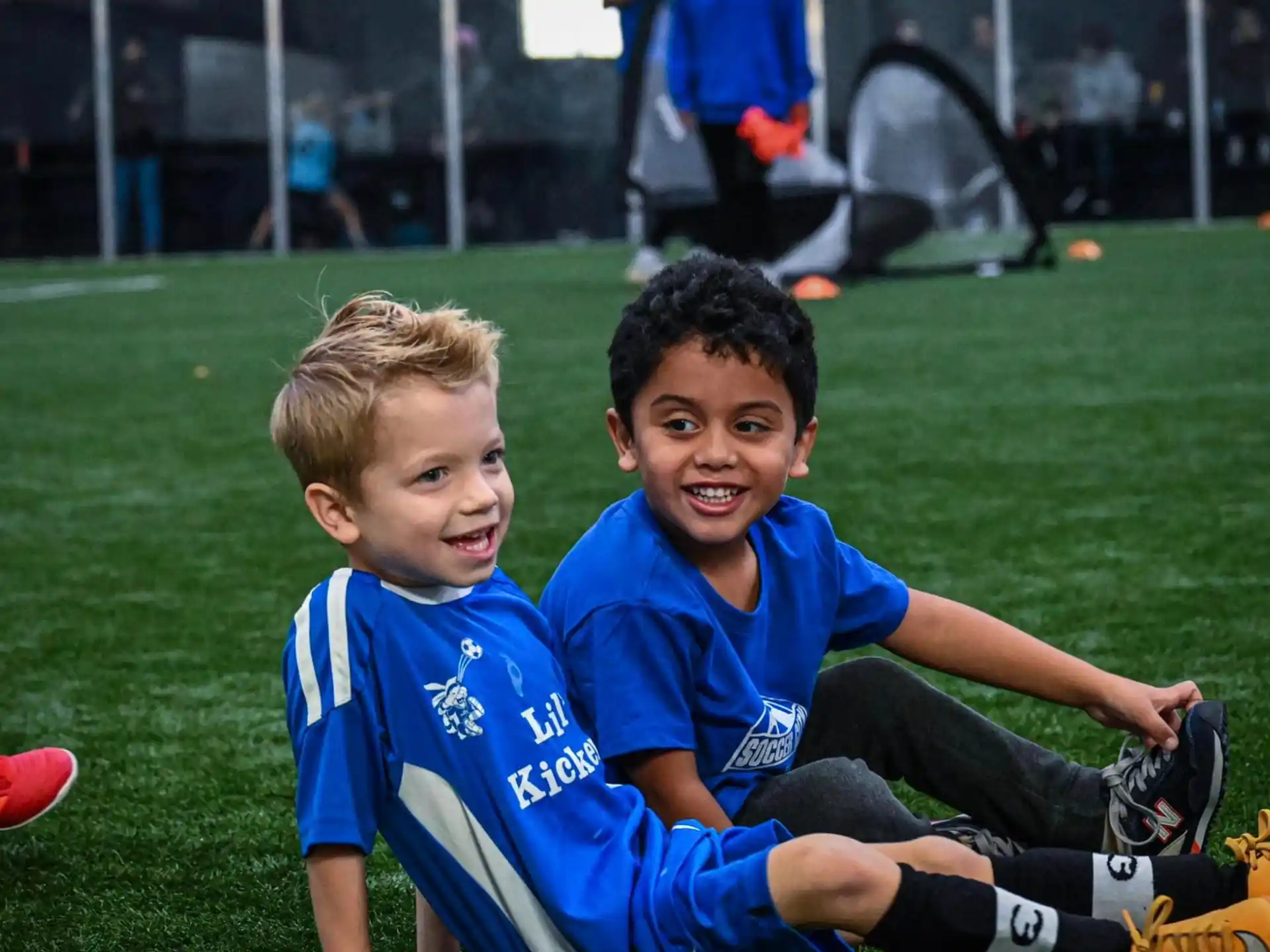 a couple of boys sitting on the grass