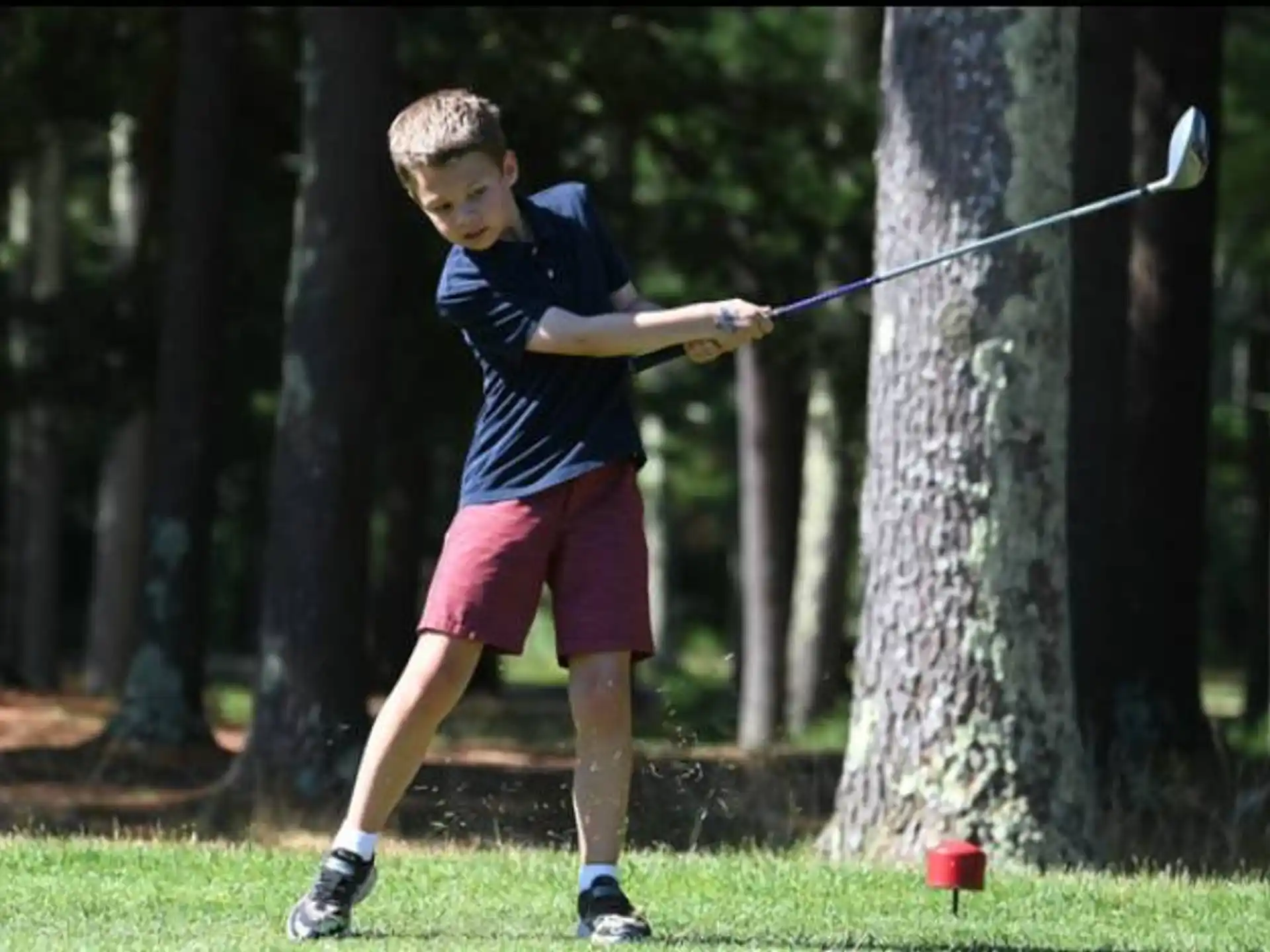 a boy swinging a bow and arrow