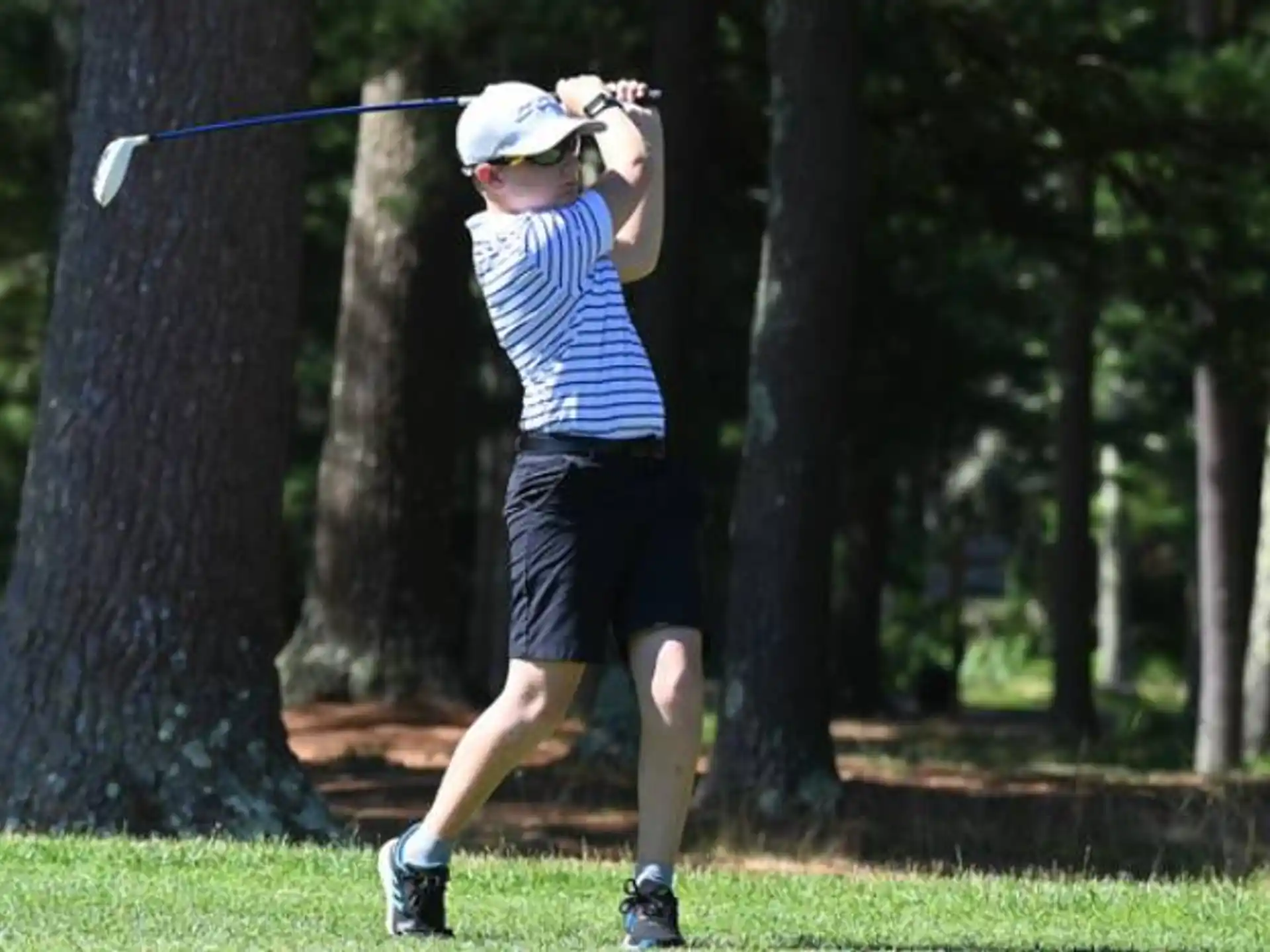 a person swinging a golf club