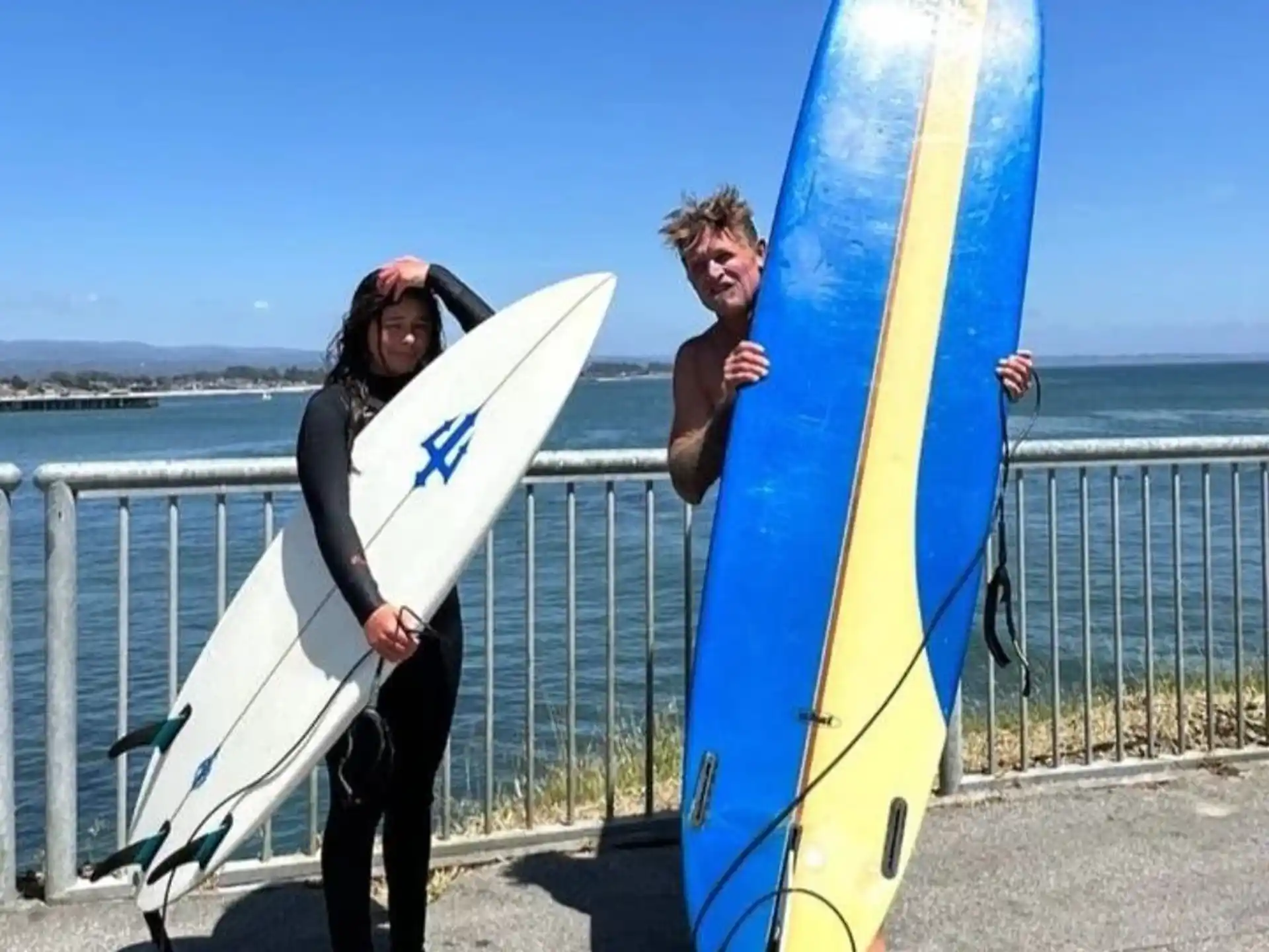 a couple of people holding surfboards