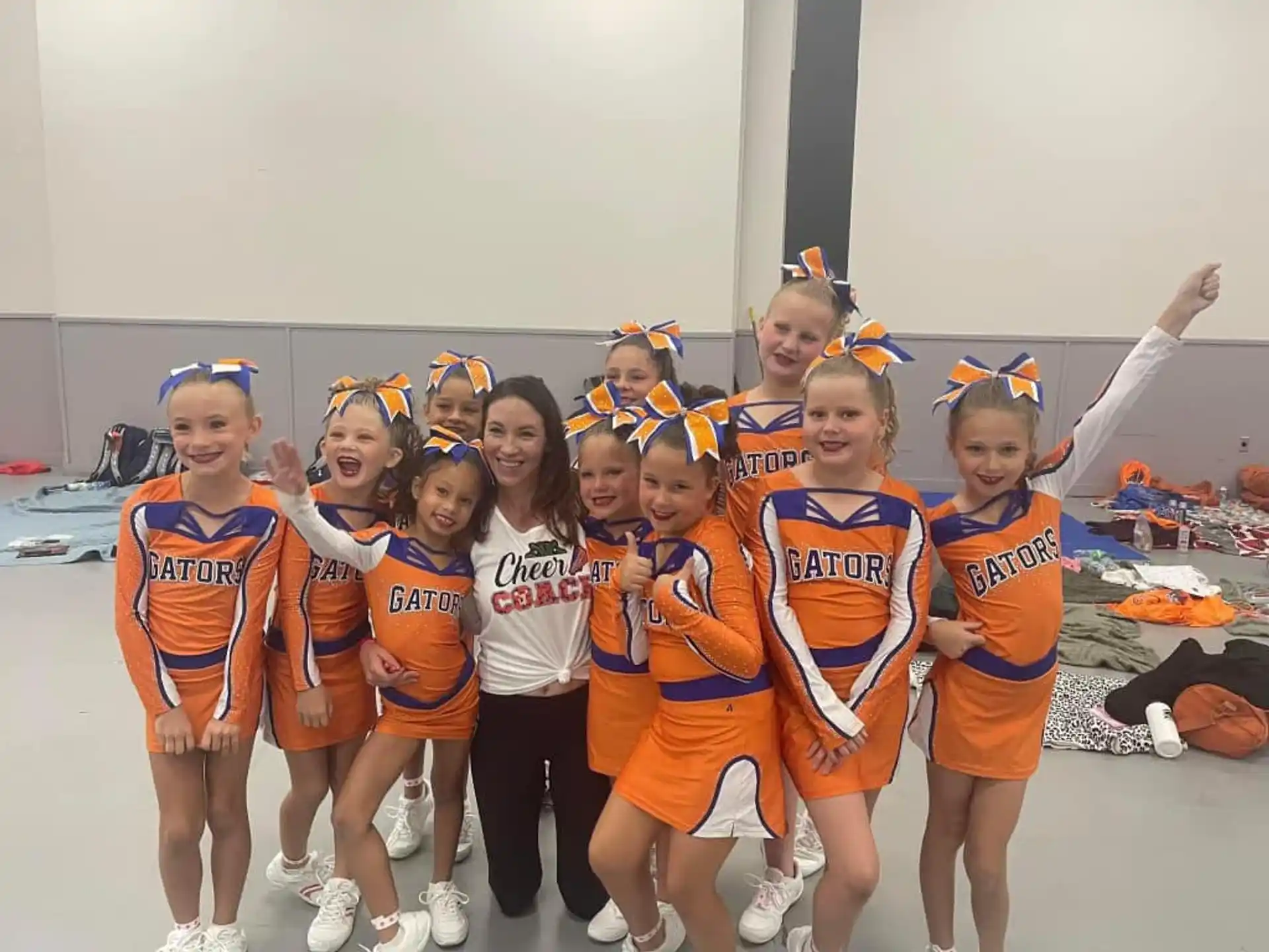 a group of girls wearing orange and white uniforms and posing for a photo