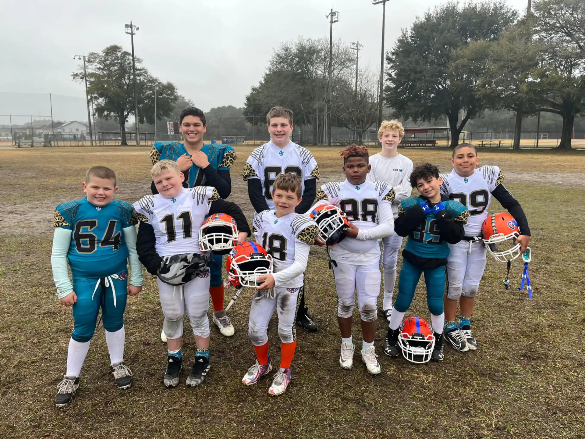 a group of people posing for a photo with footballs