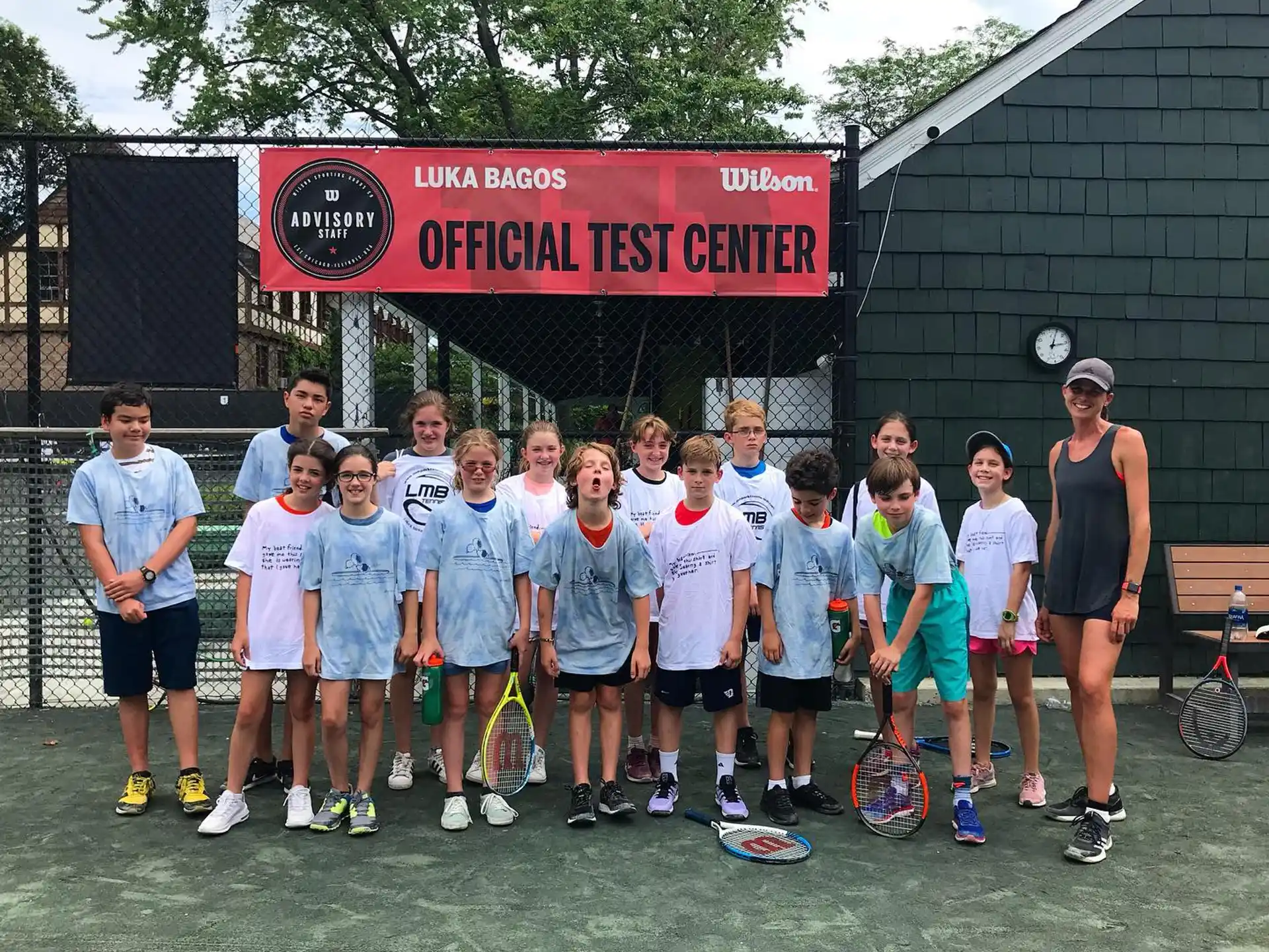 a group of people posing for a photo with tennis rackets