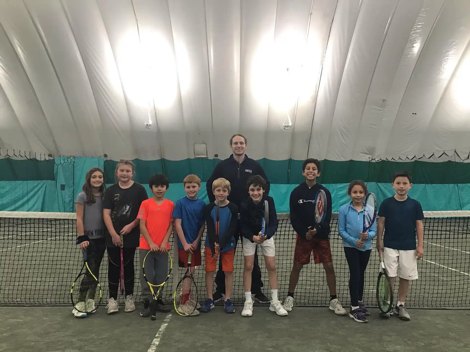 a group of people holding tennis rackets