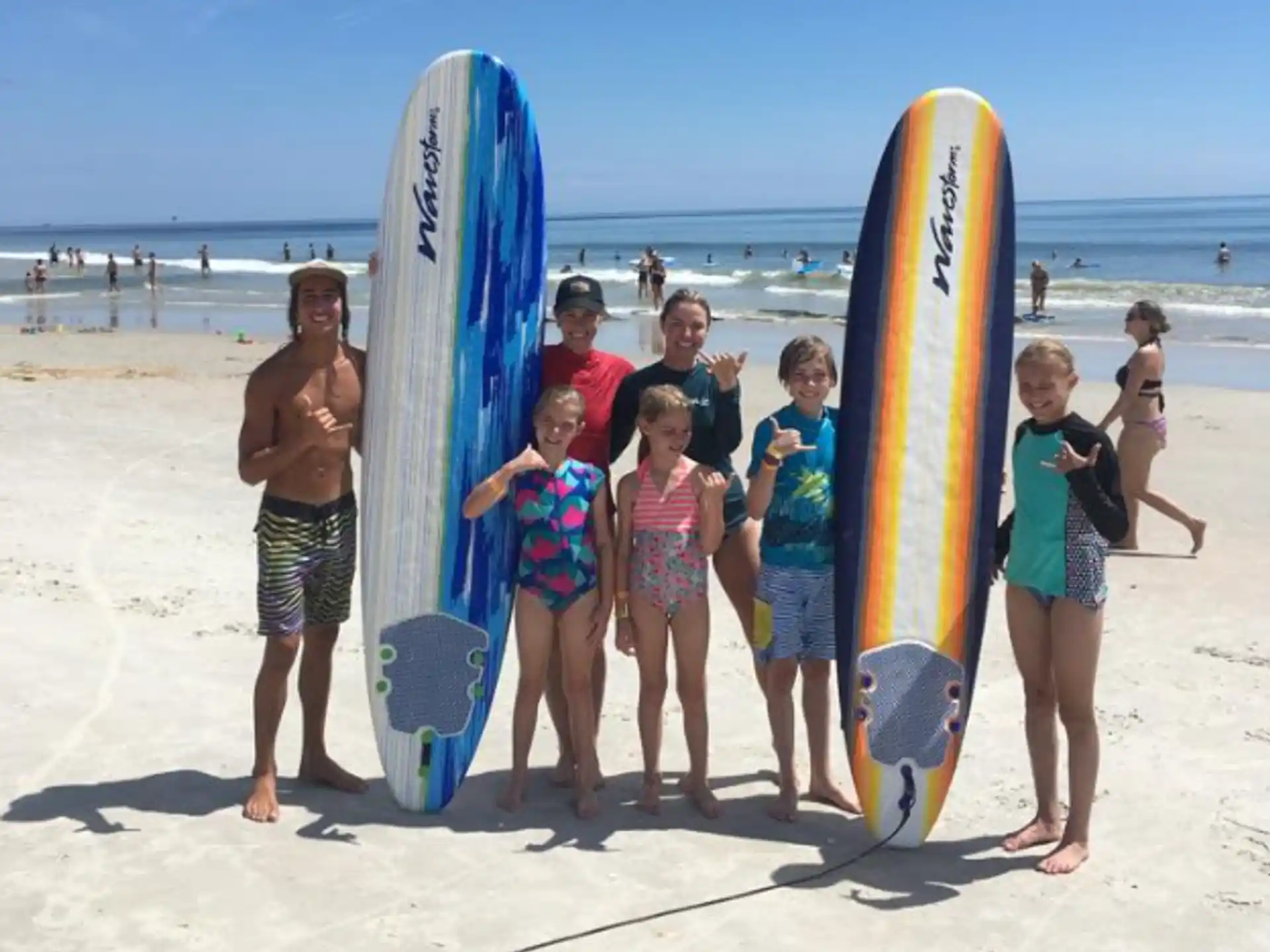 a group of kids standing next to surfboards on a beach