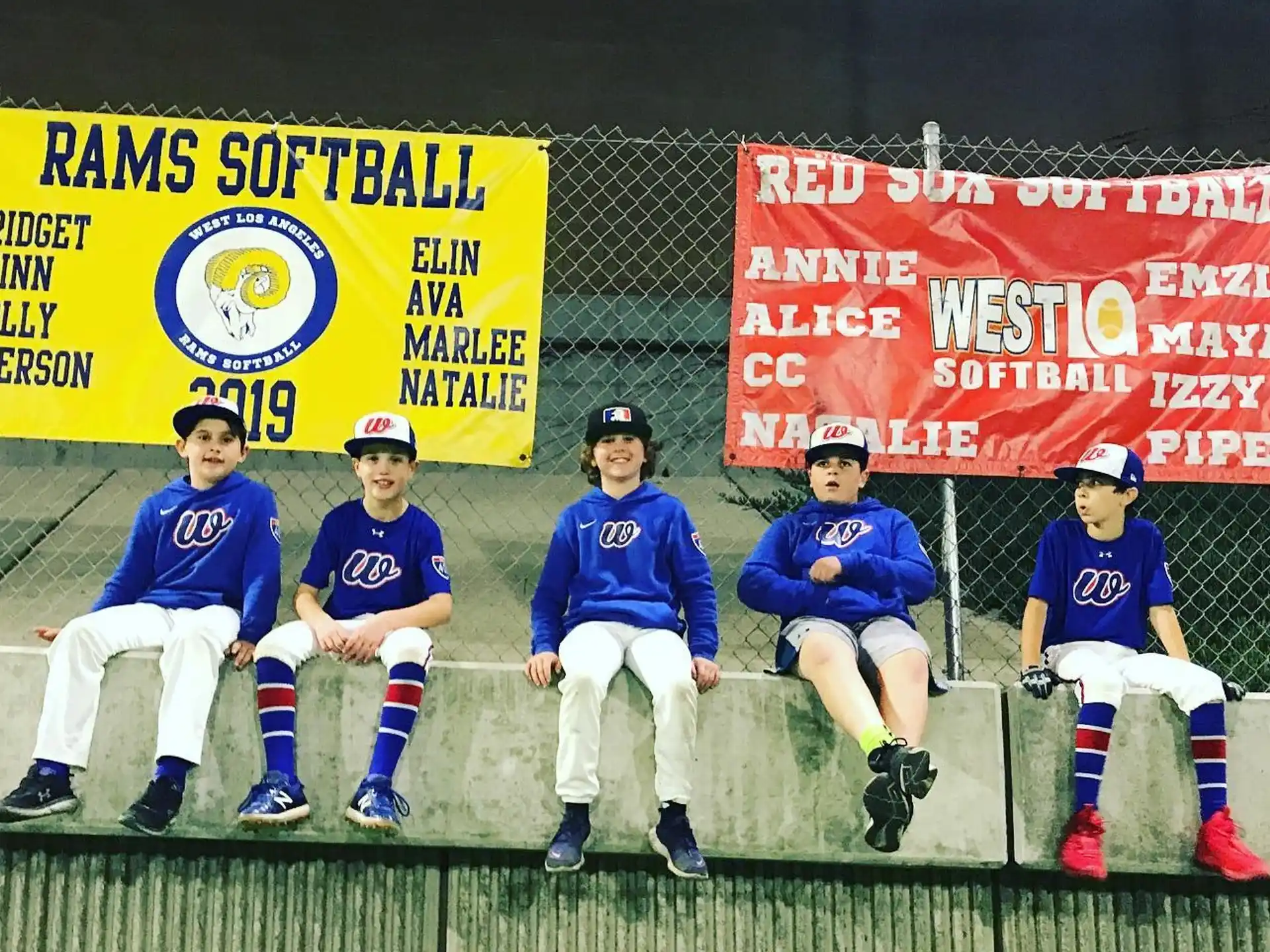 a group of people sitting on a bench posing for the camera