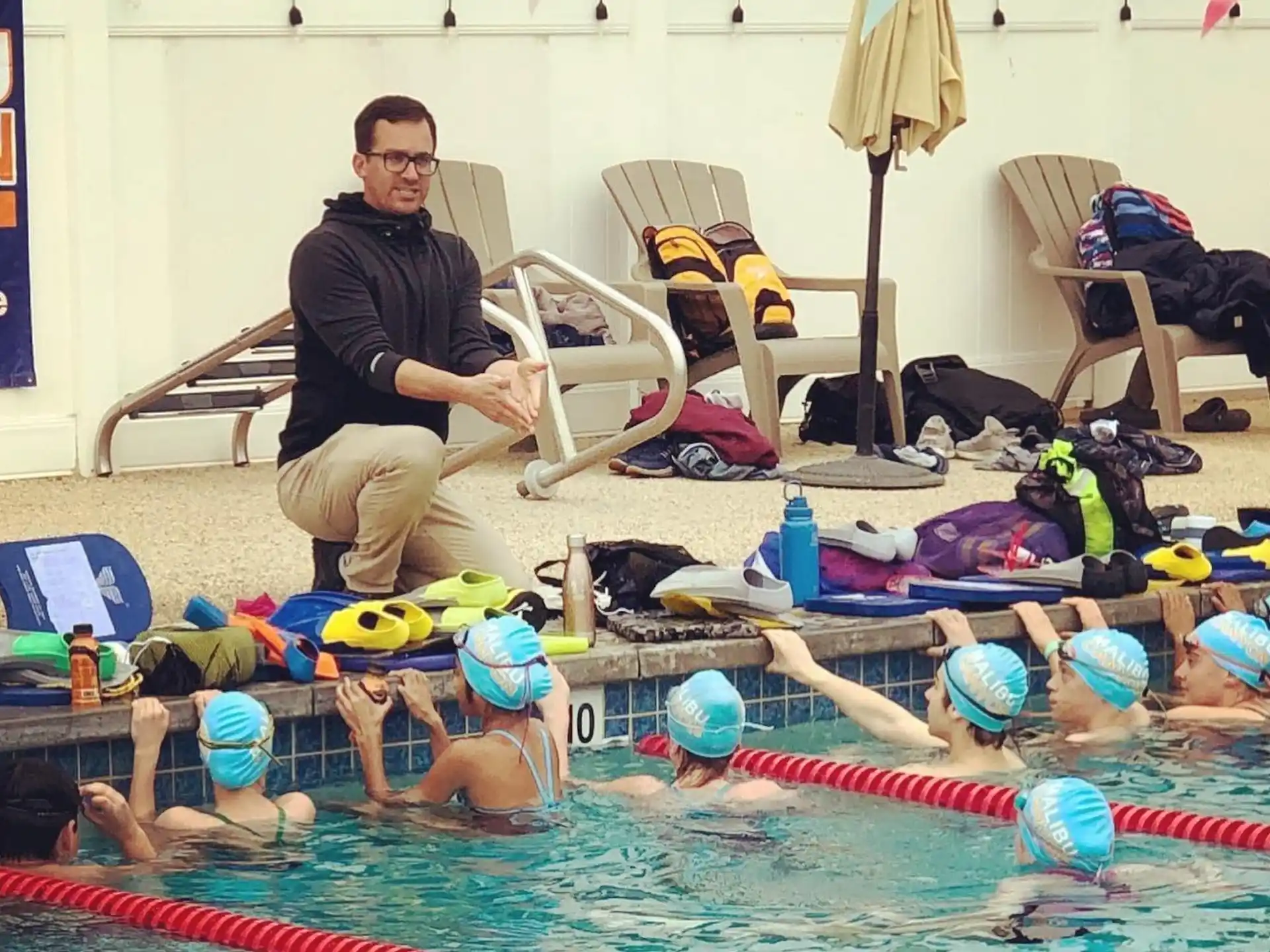 a person sitting in a pool with a group of people in it