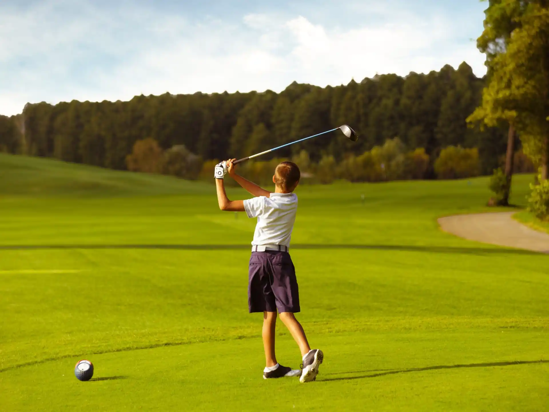 a boy swinging a golf club