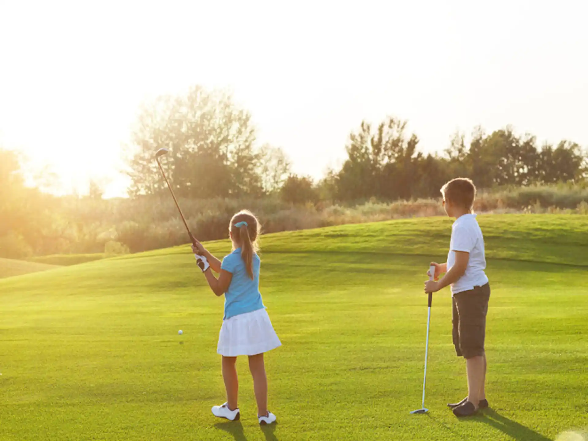 a couple of children playing golf