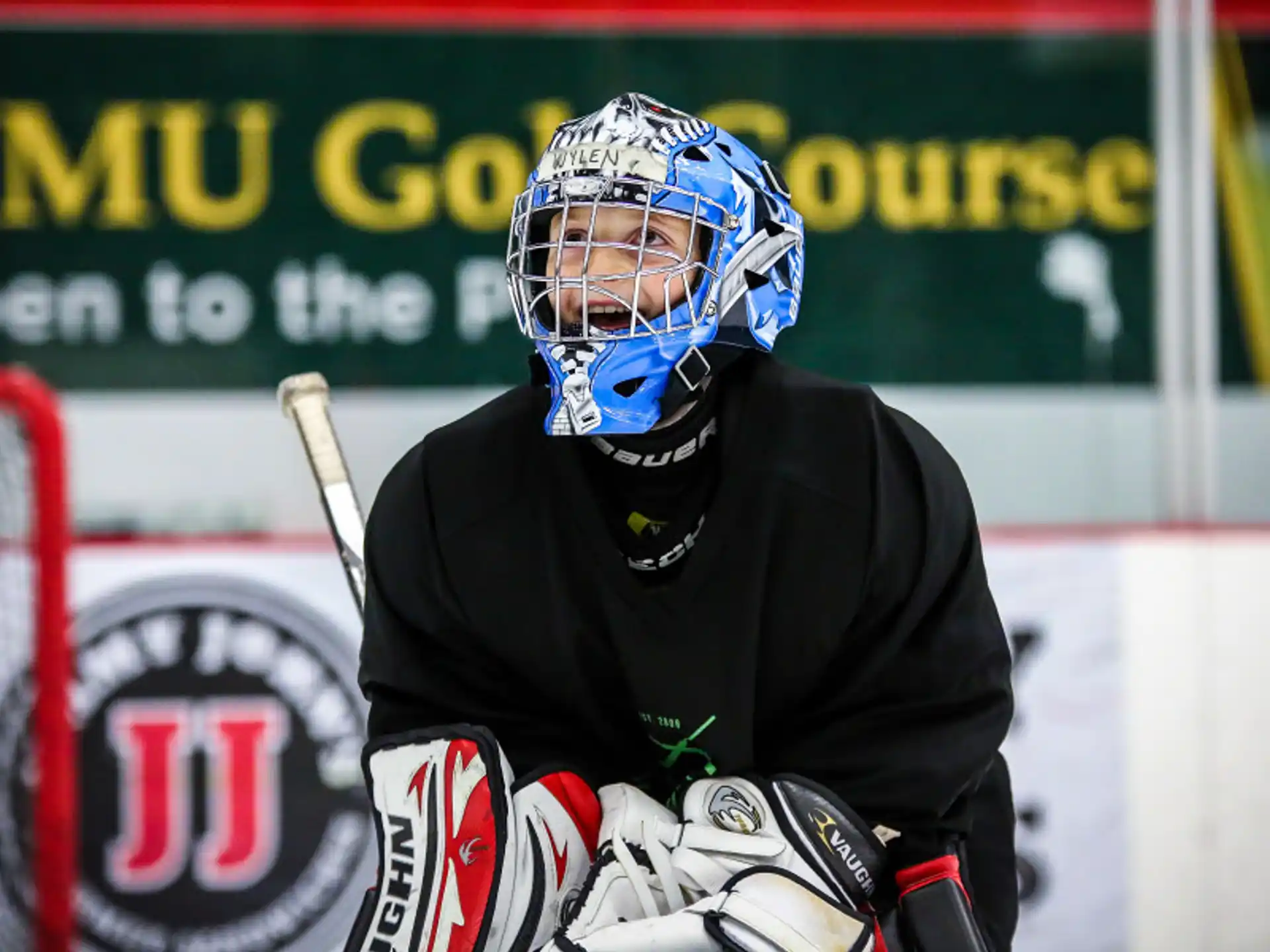 a person wearing a helmet and kneeling in front of a goal