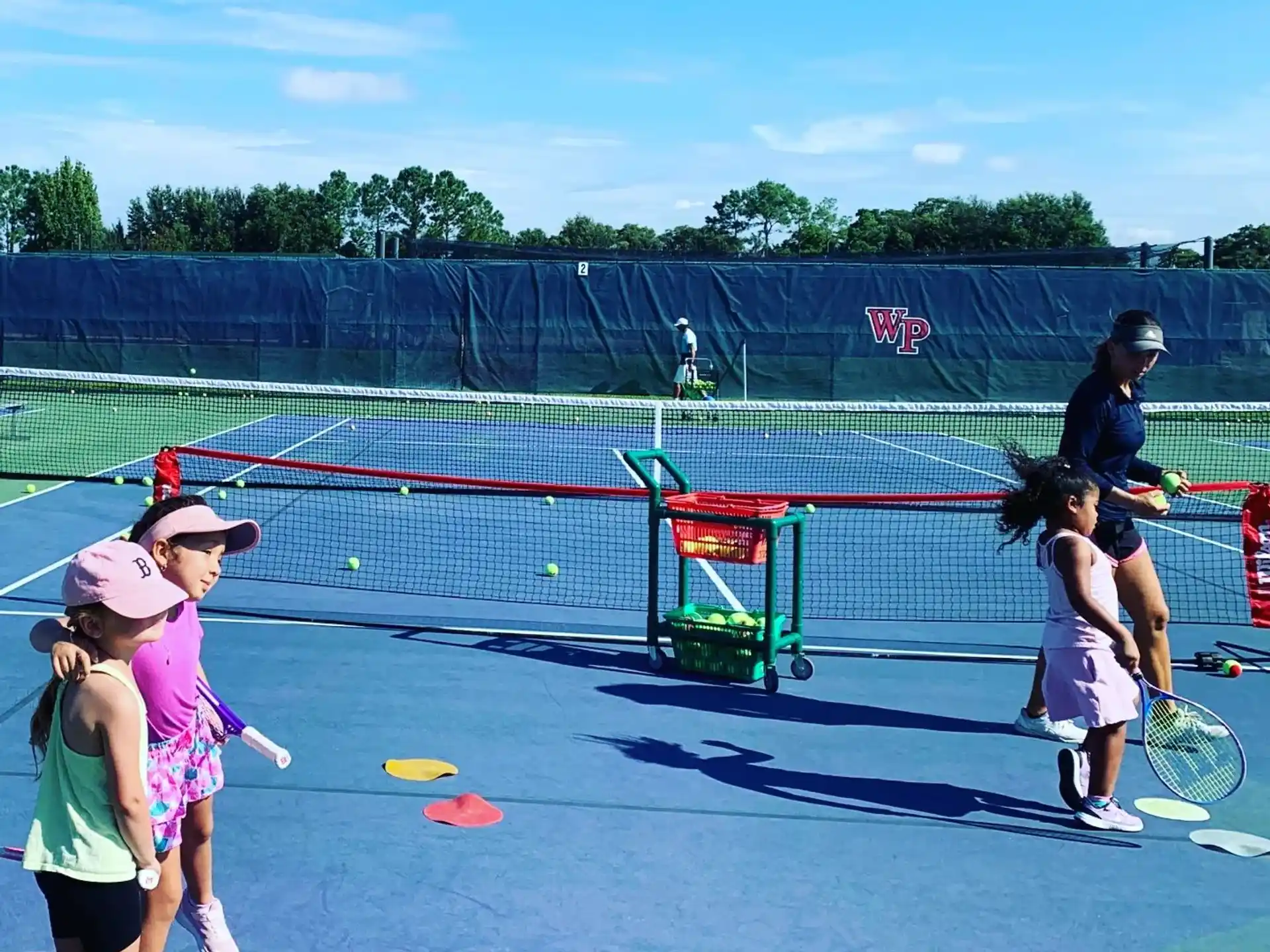 a group of kids playing tennis