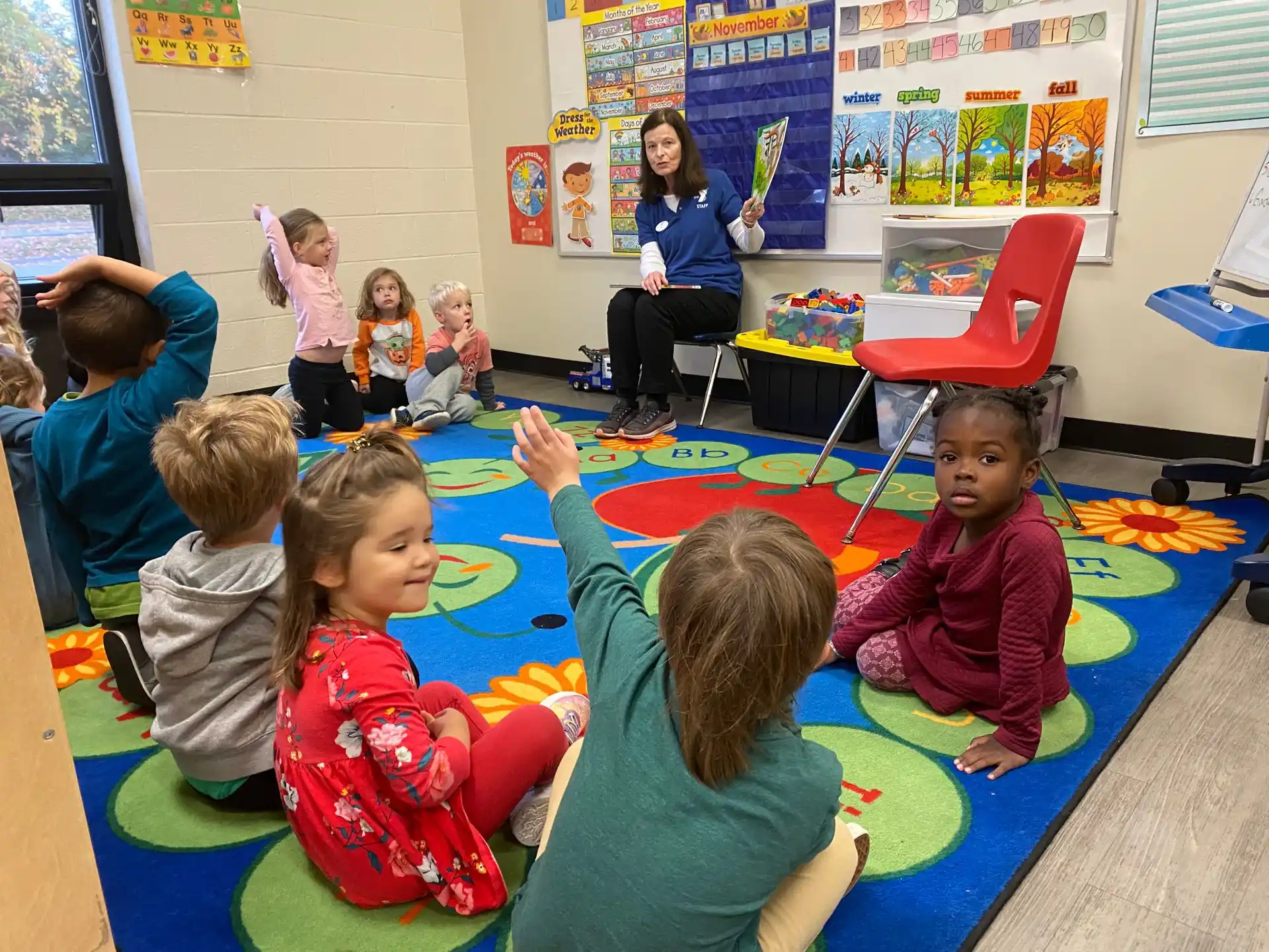 a group of children sitting on the floor in a classroom