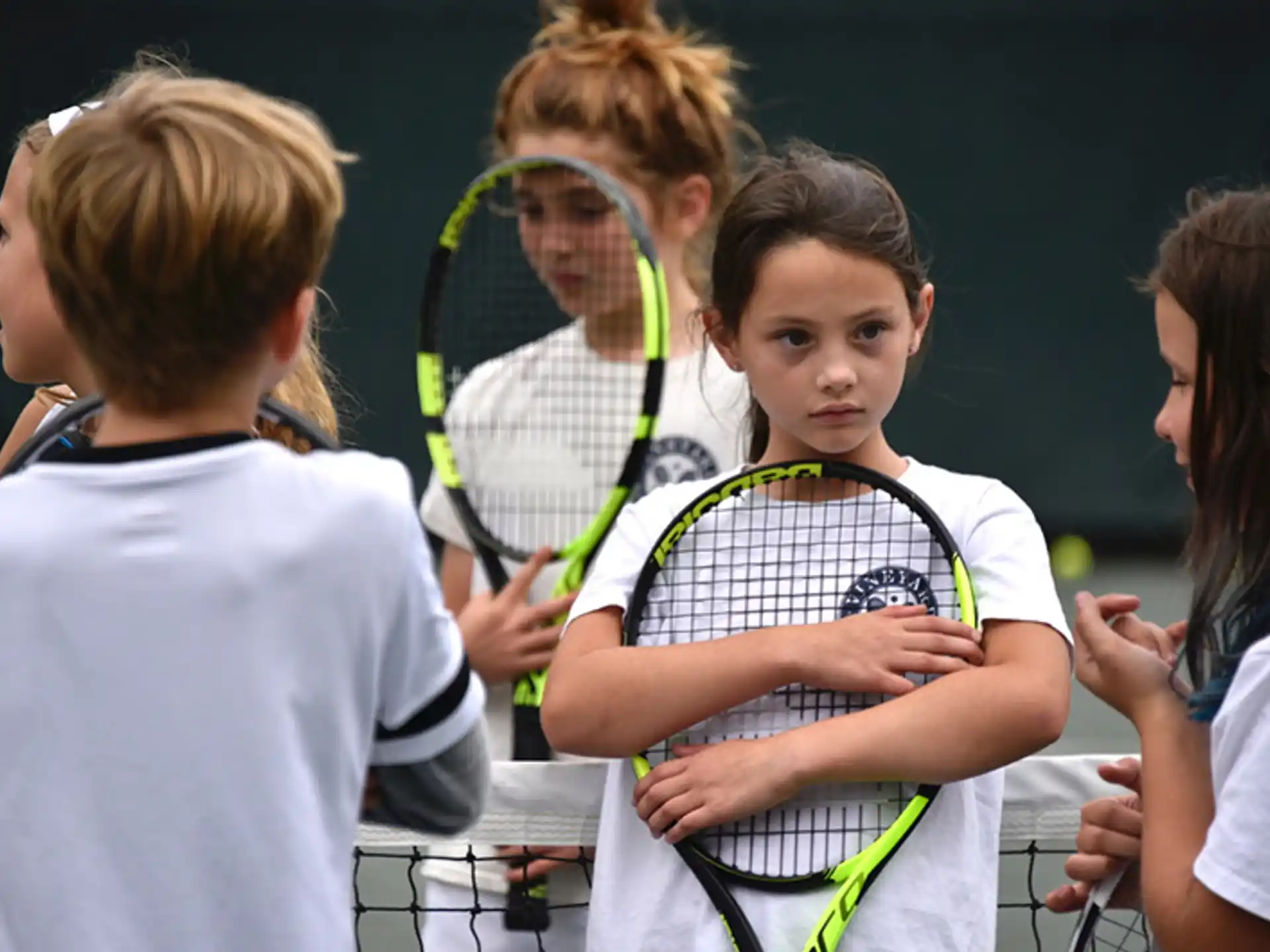 a group of kids playing tennis