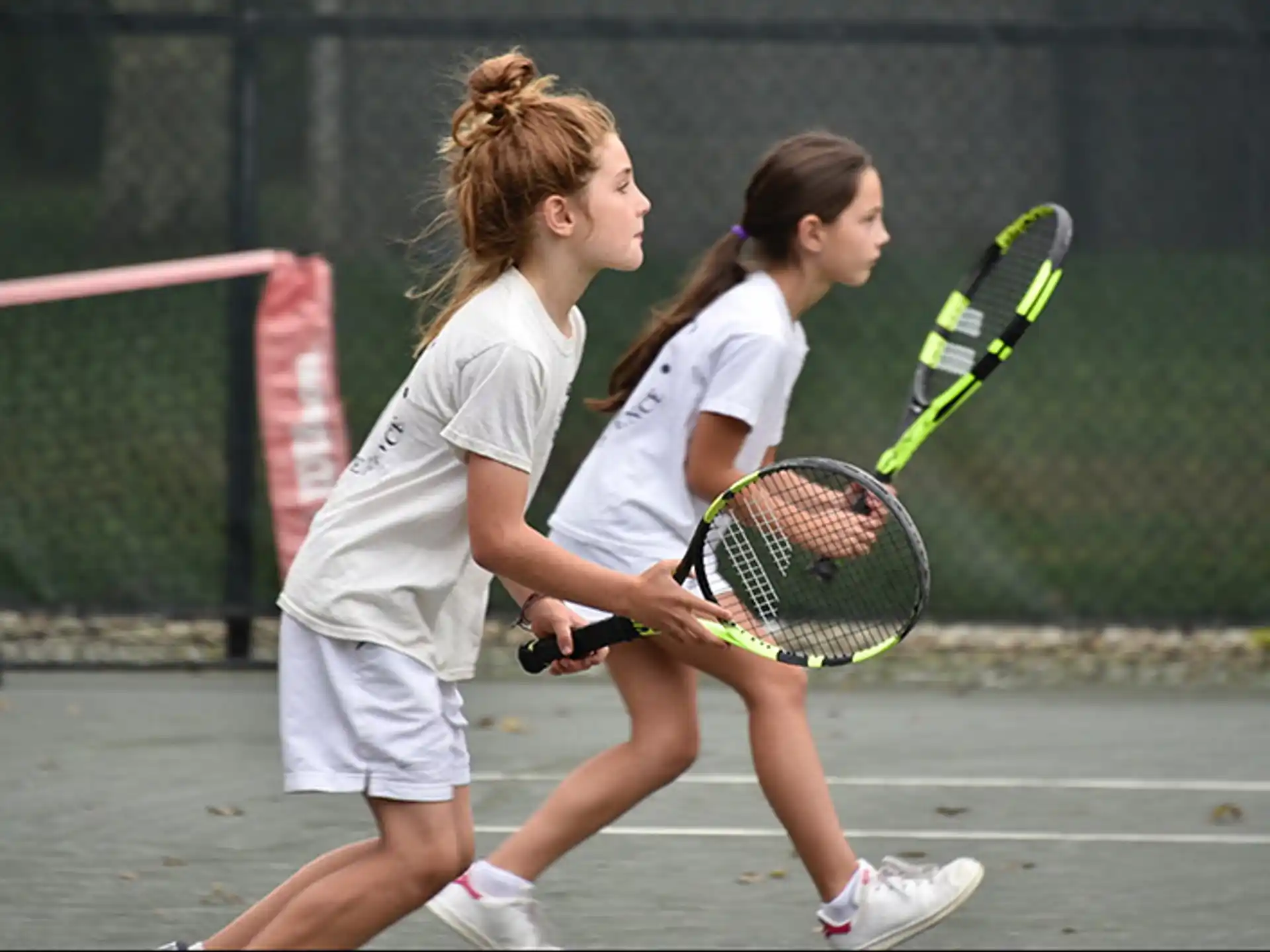 girls playing tennis on court