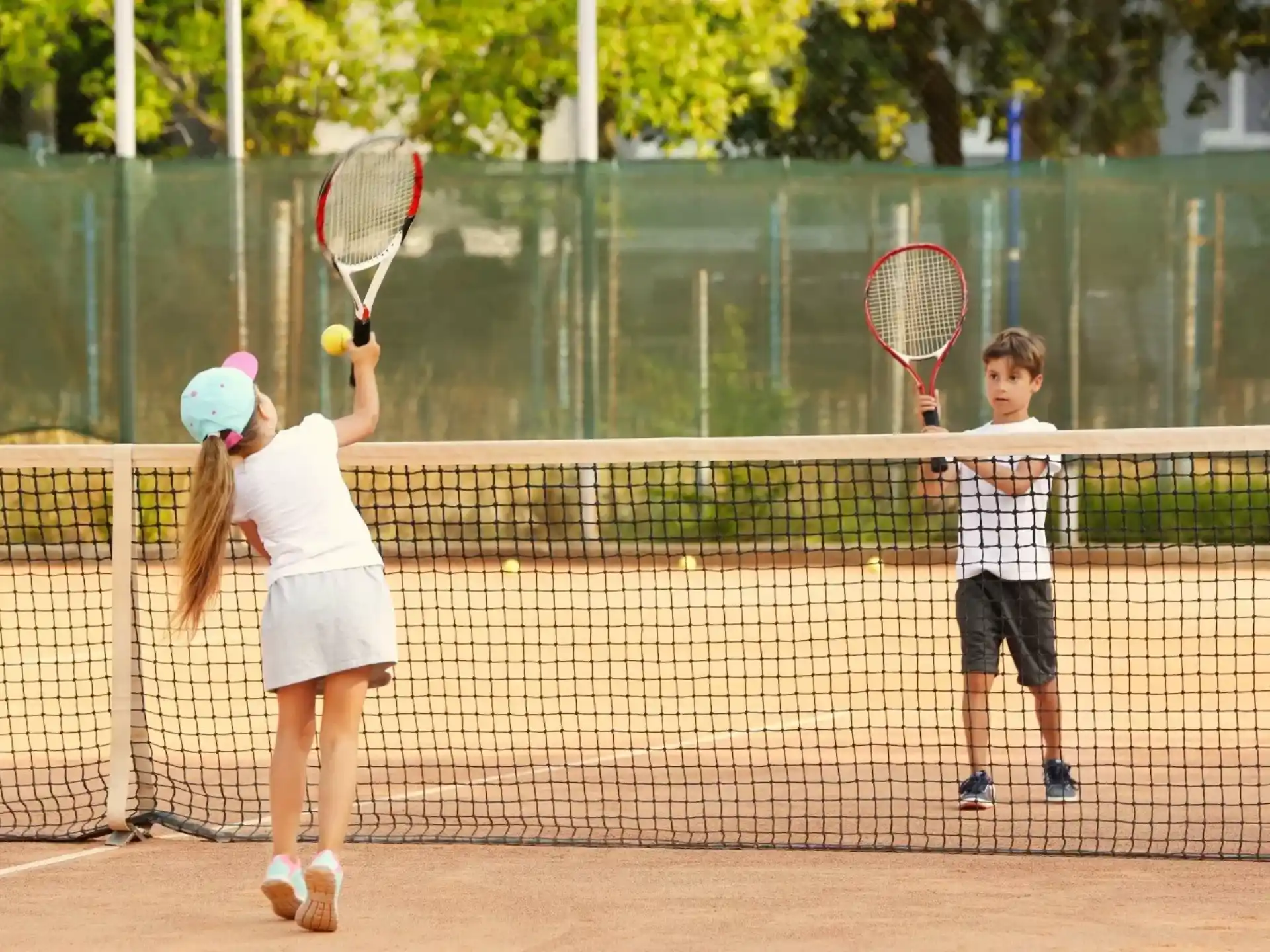 a couple of kids playing tennis