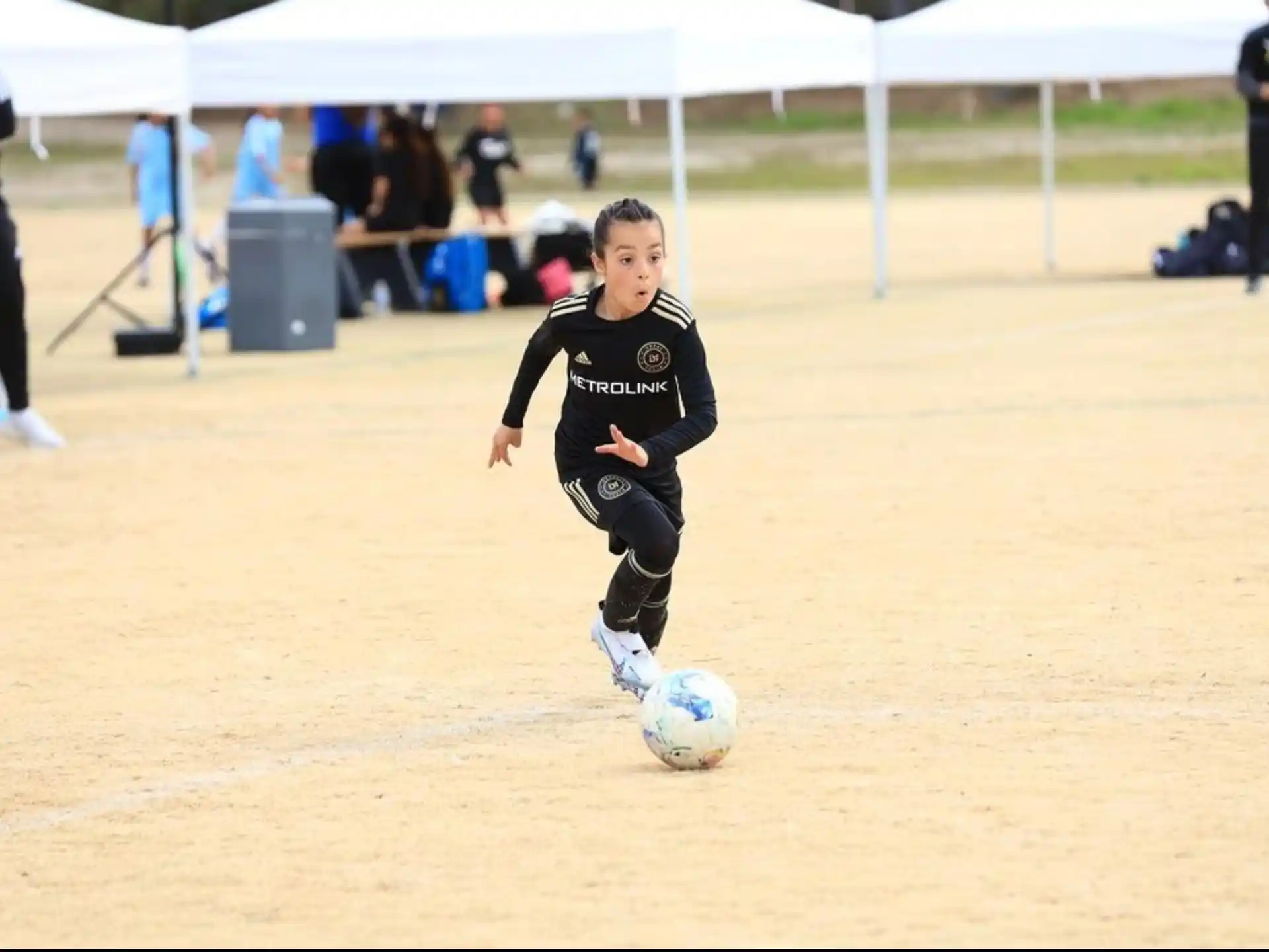 a boy kicking a football ball