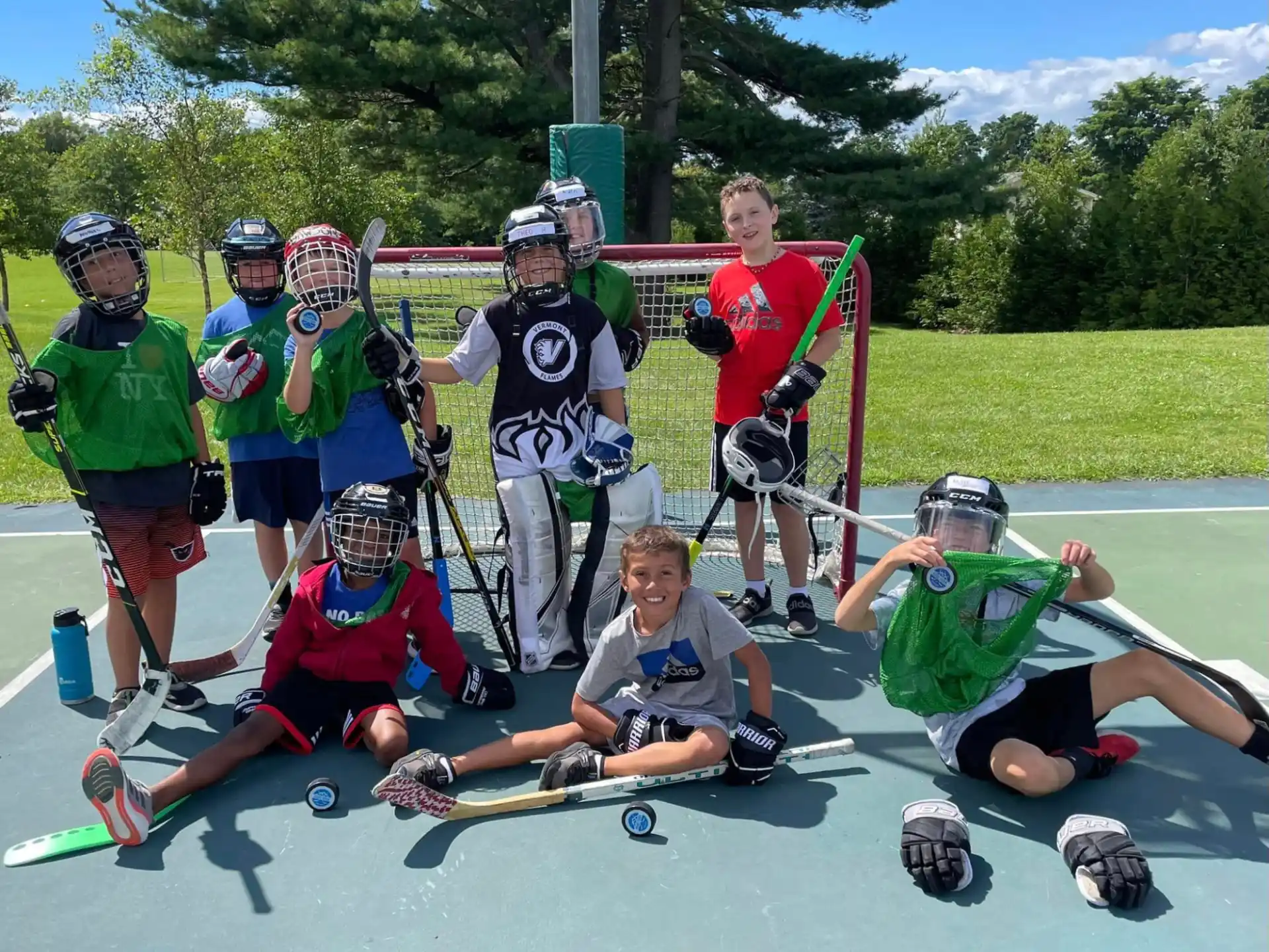 a group of people wearing helmets and holding sticks posing for the camera