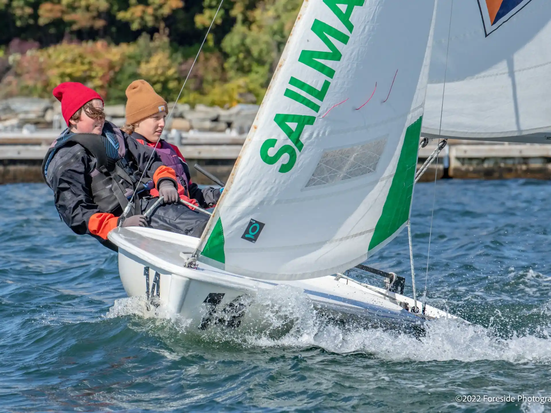 a couple of people on a sailboat on water