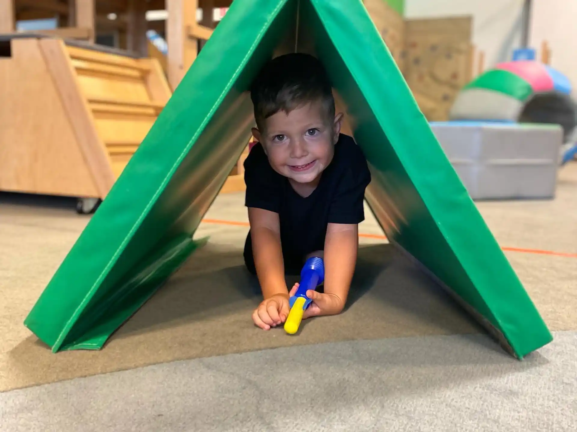 a child in a green tent