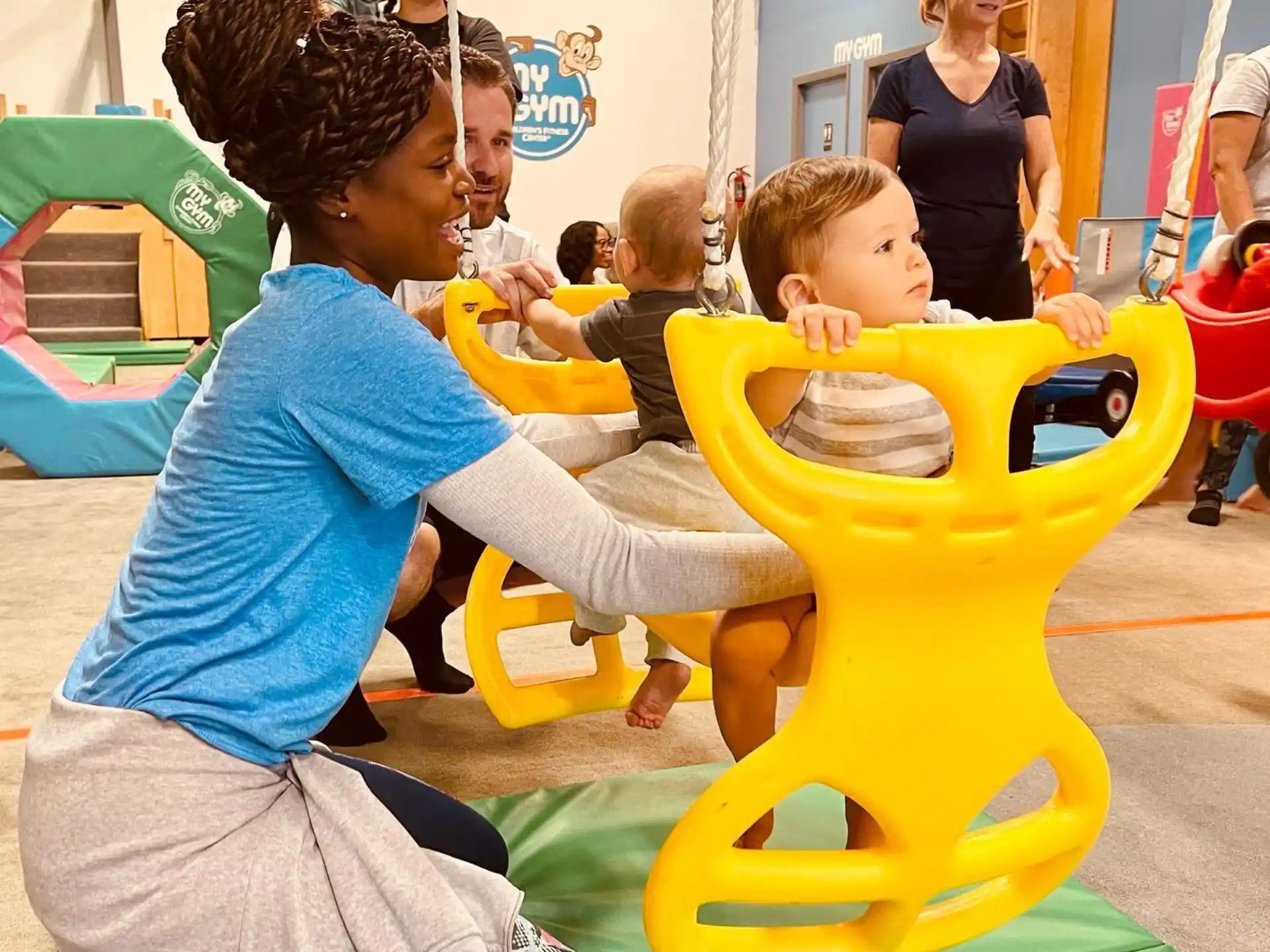 a woman and a child playing with a yellow toy