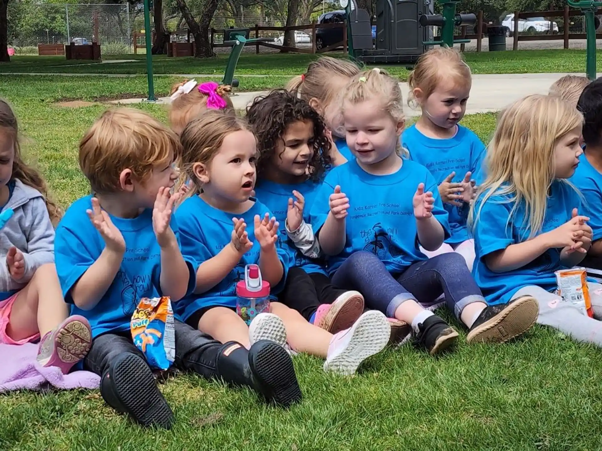 a group of children sitting on the grass
