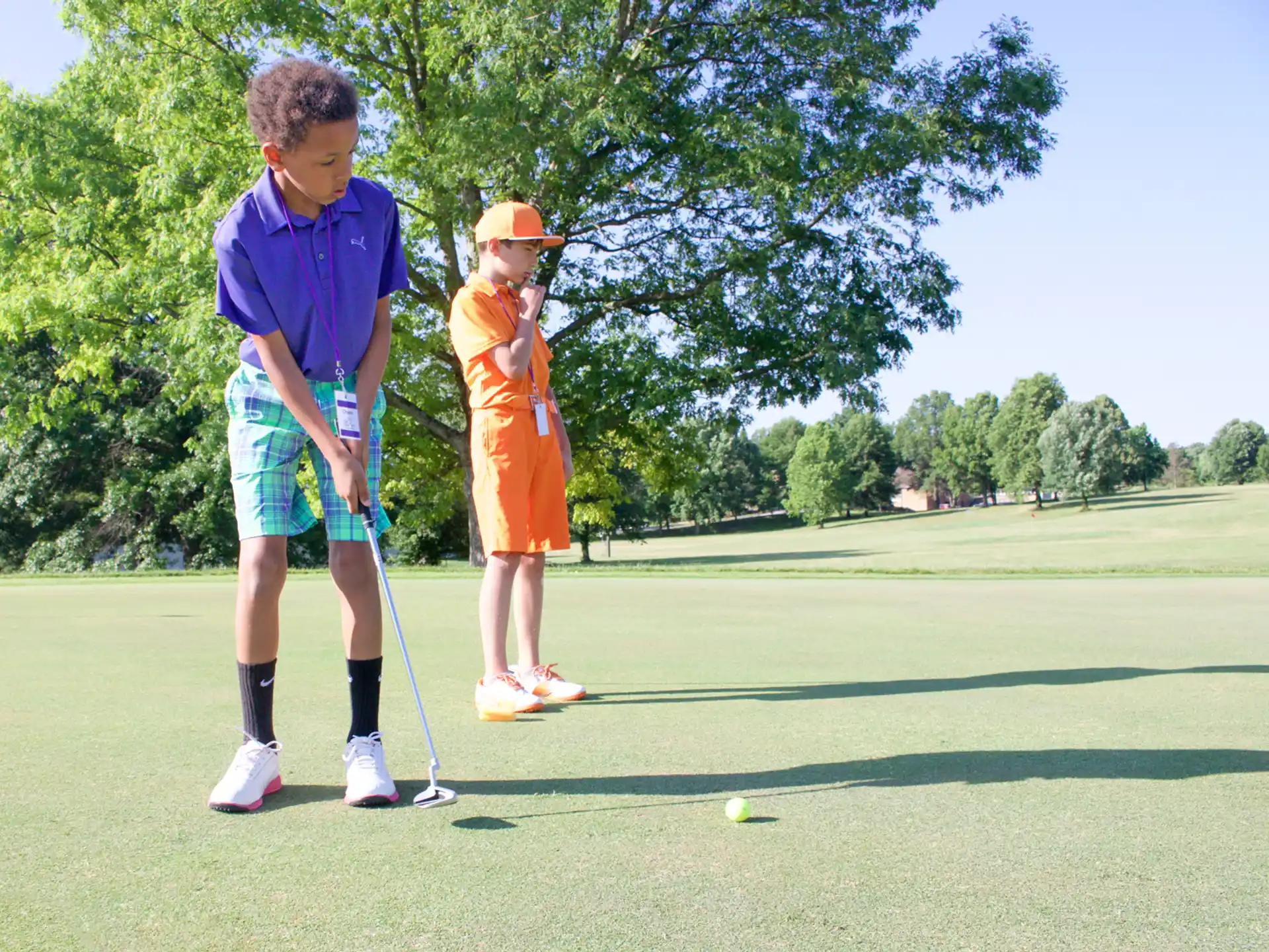 a person and a boy playing golf
