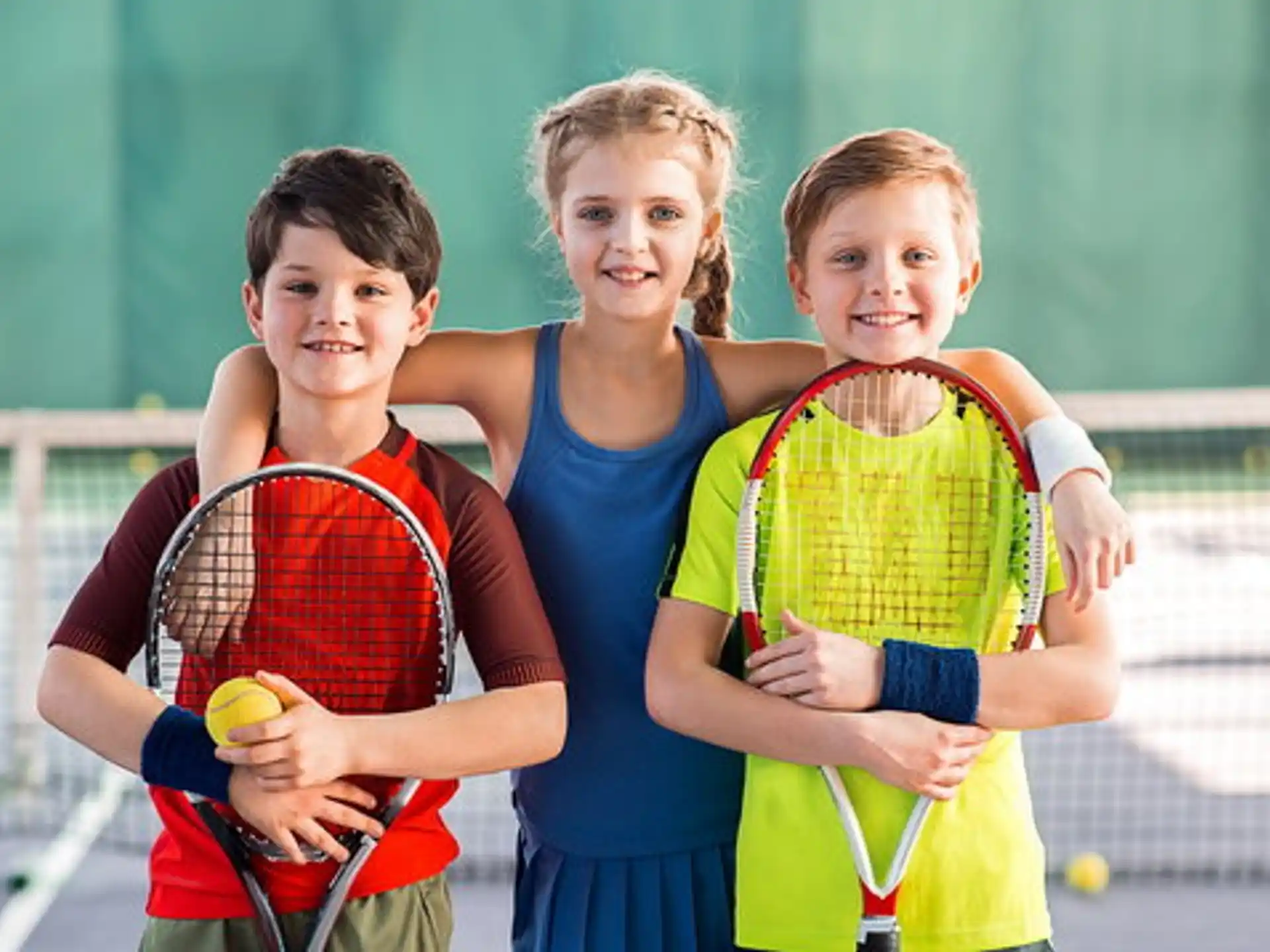 a group of kids holding tennis rackets