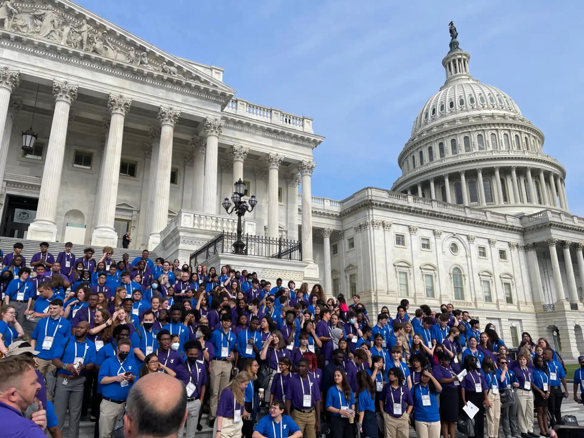 a large crowd of people outside of a white building