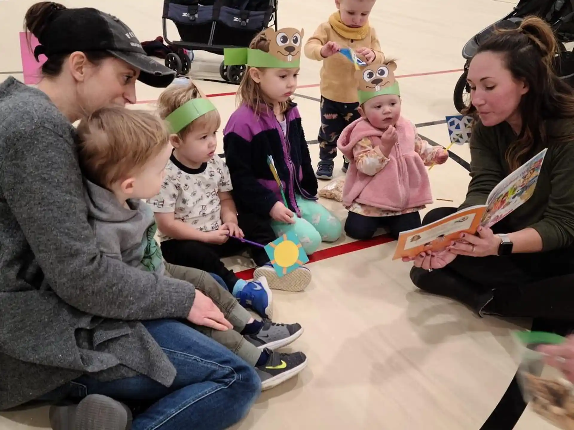 a group of people sitting on the floor with a baby