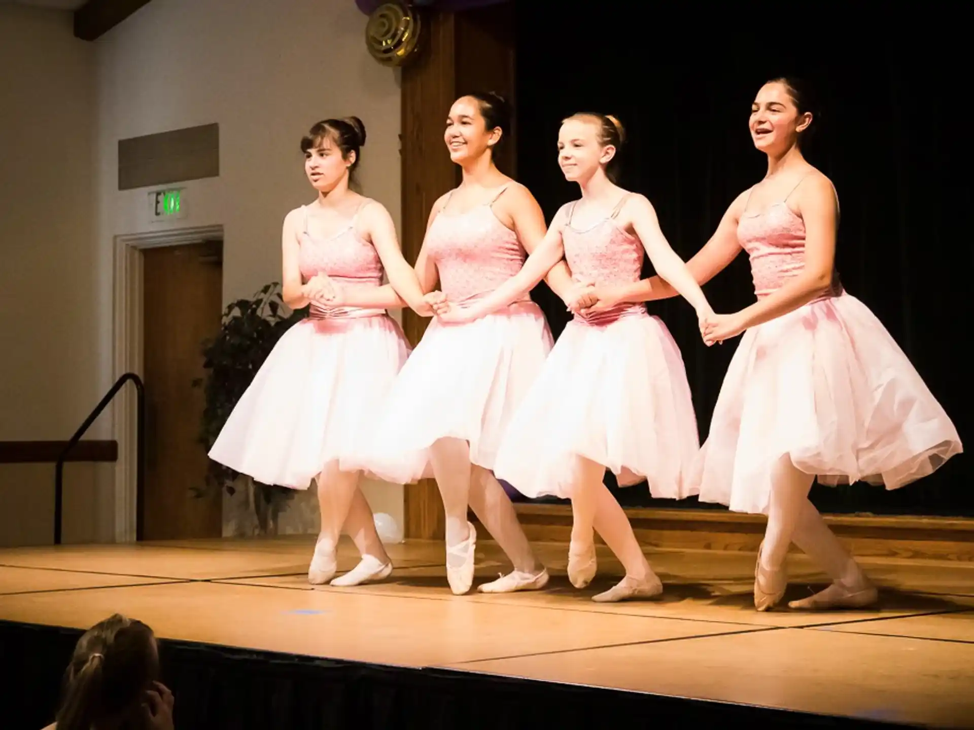a group of women in dresses on a stage