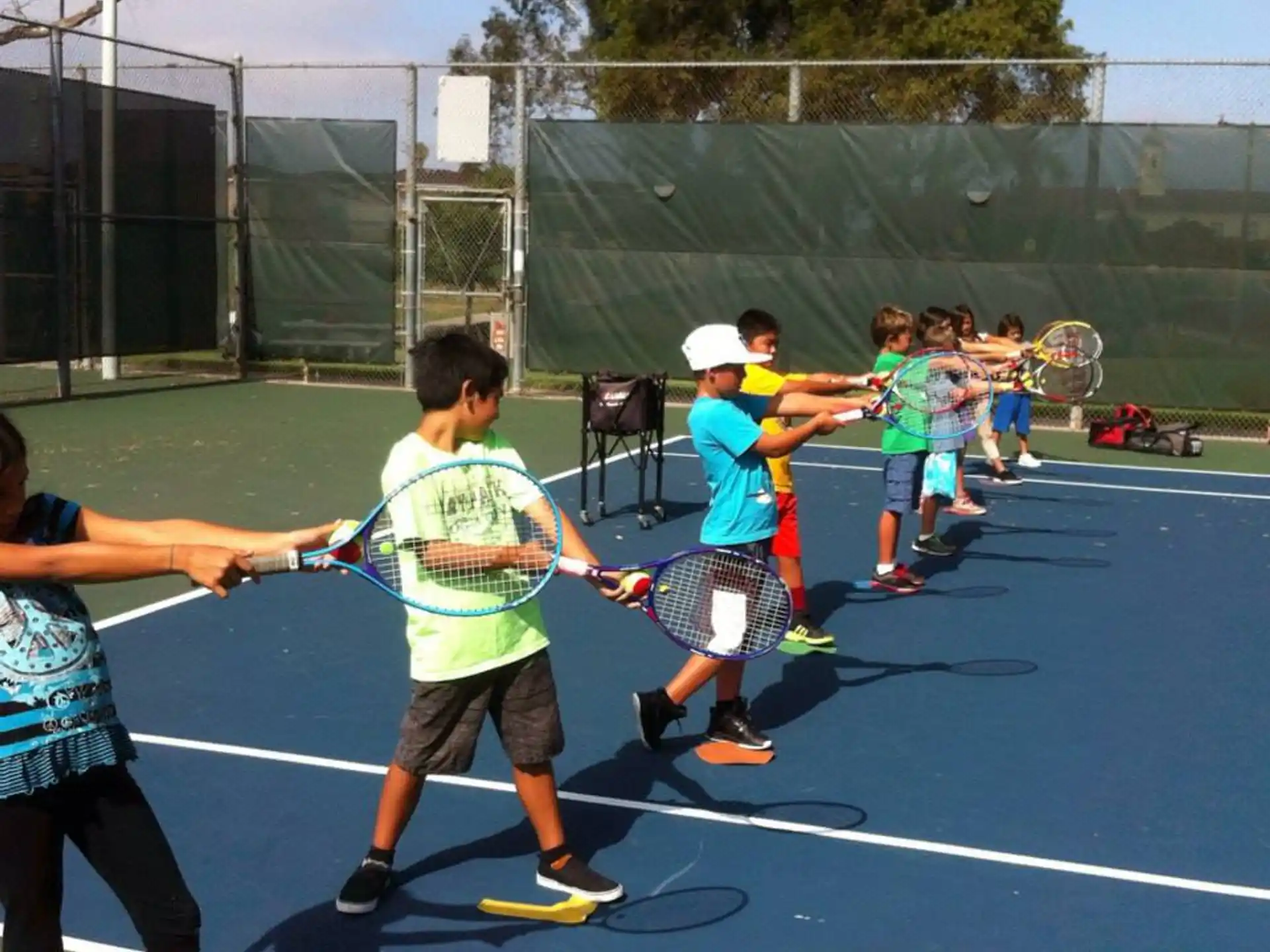 a group of kids playing tennis
