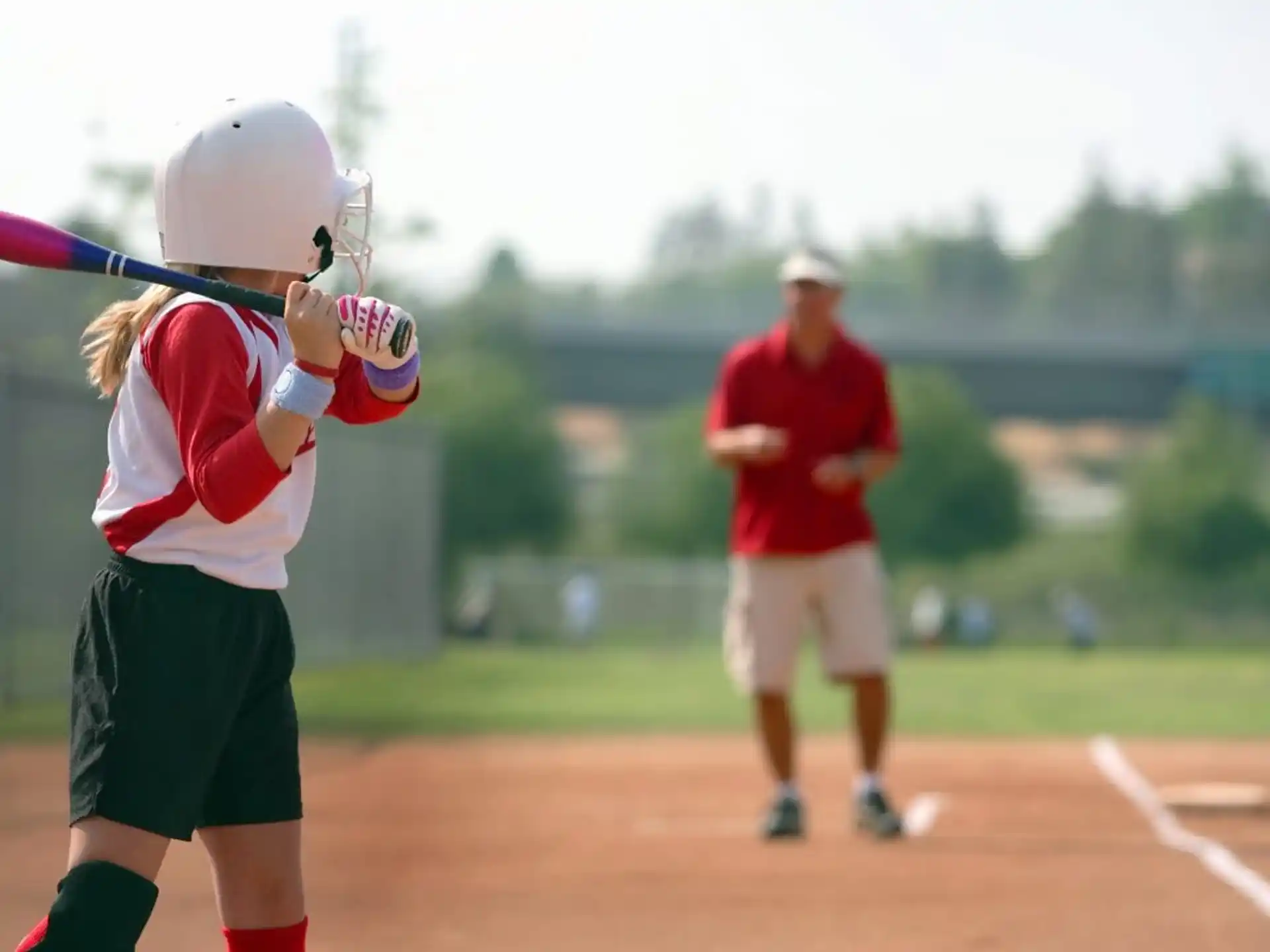 a girl swinging a baseball bat