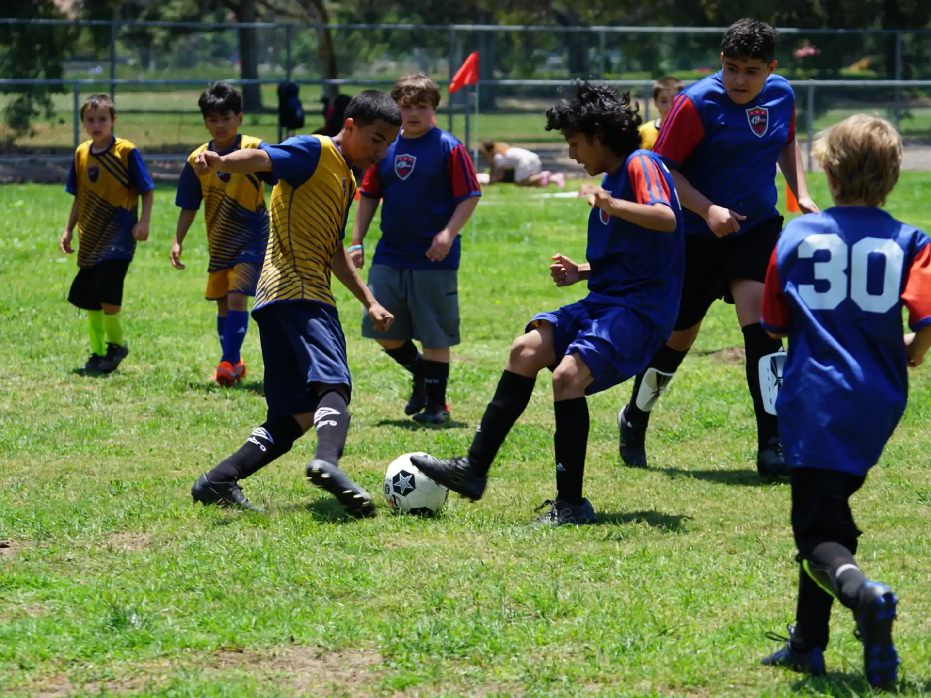 a group of kids compete over a football ball