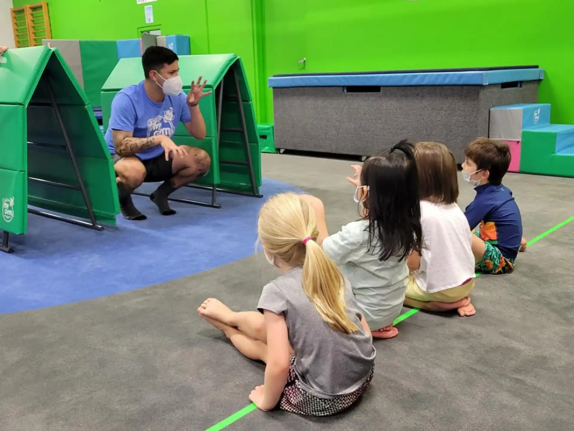 a group of children sitting on the floor in a classroom