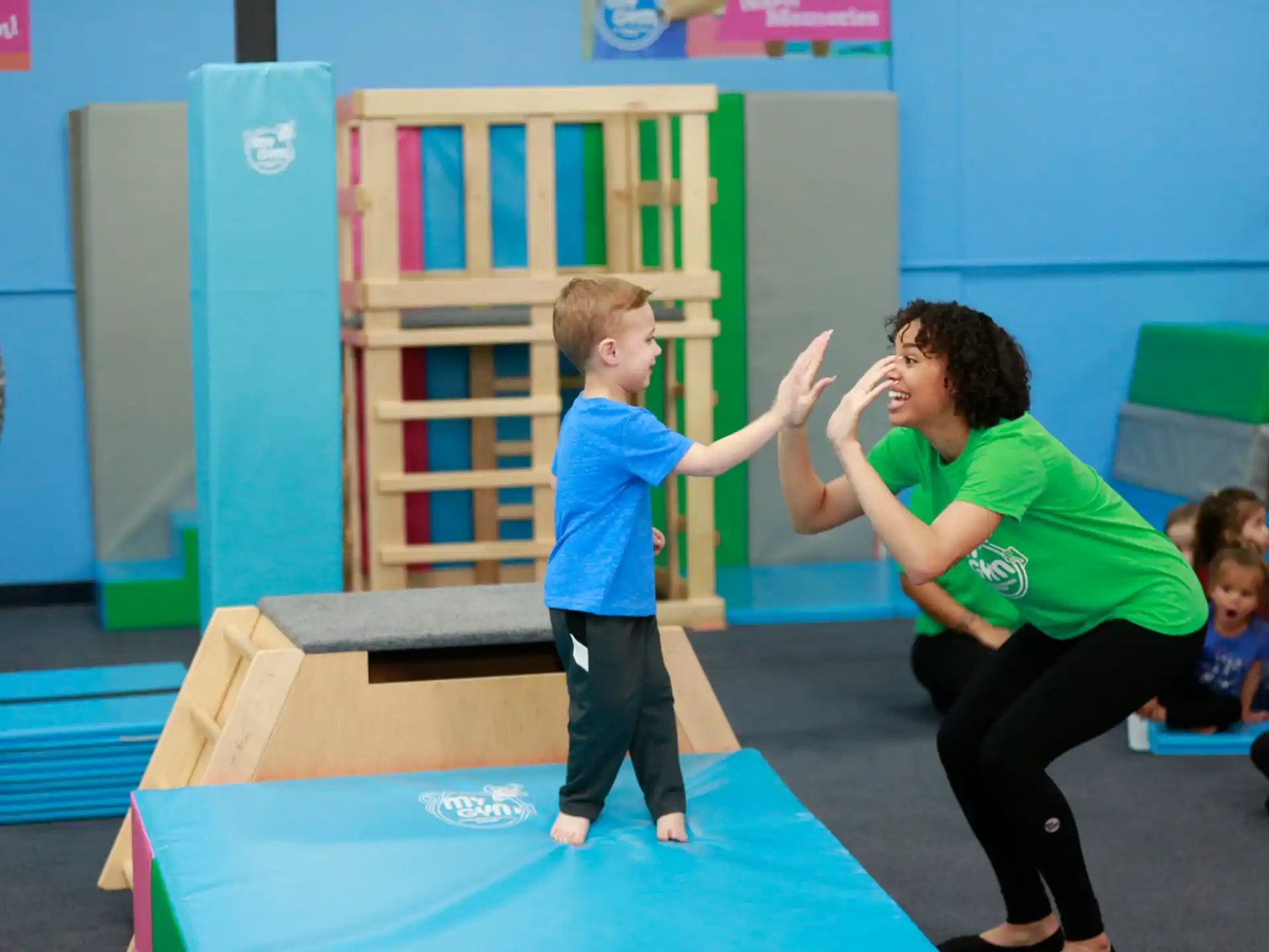 a person and a child playing on a mat in a classroom