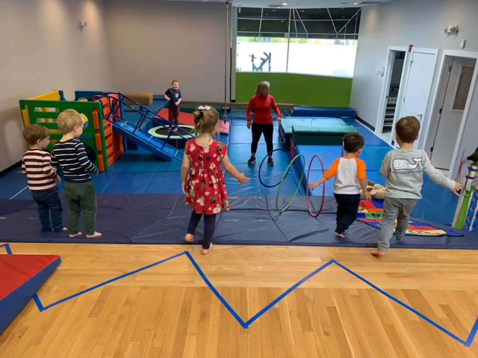 a group of children playing on a mat in a room