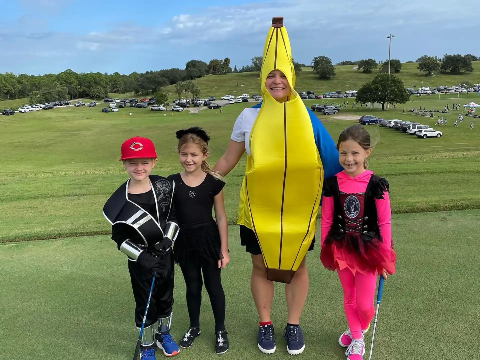 a group of kids posing with a person in a garment
