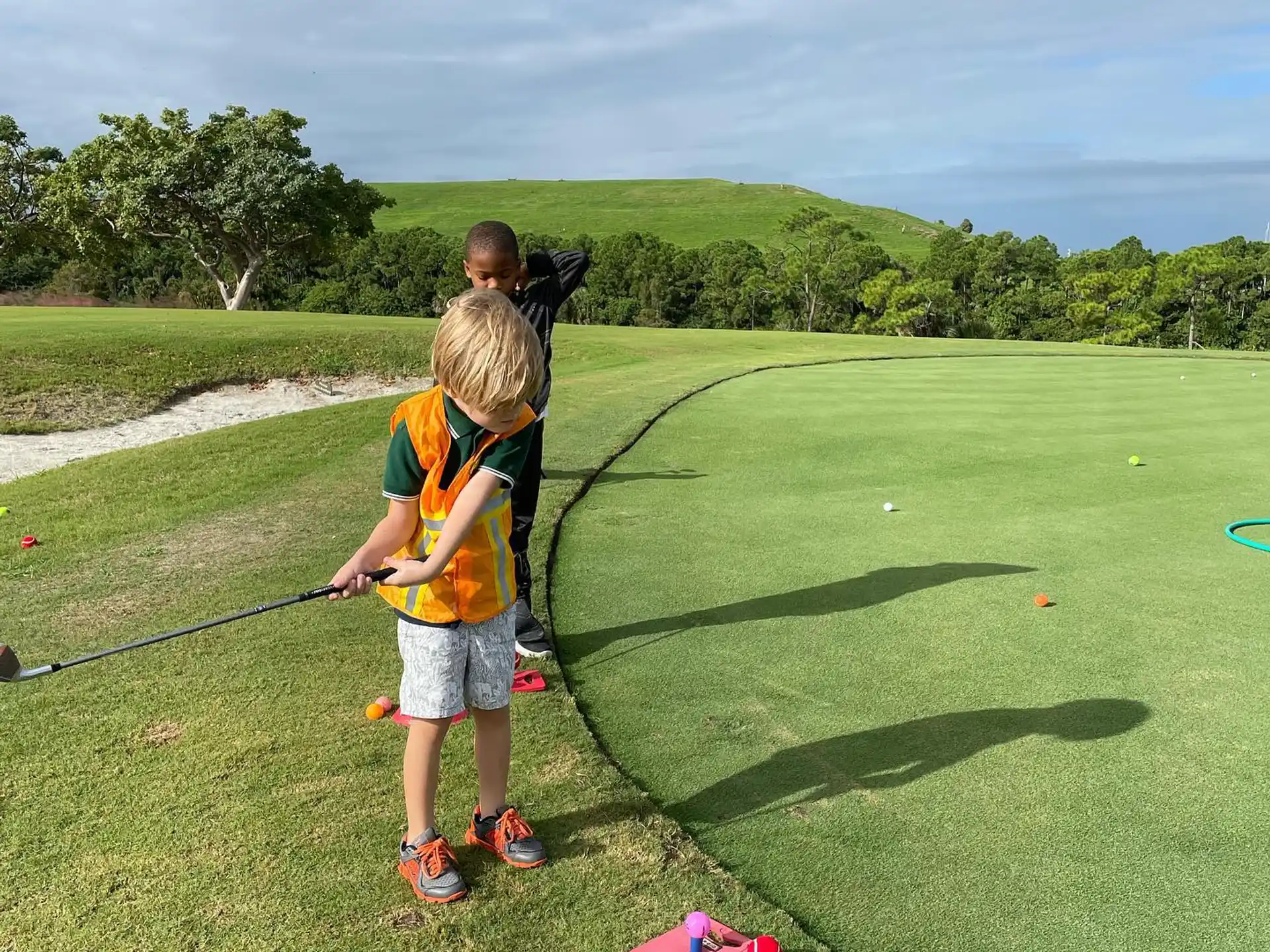 a person and a child on a golf course
